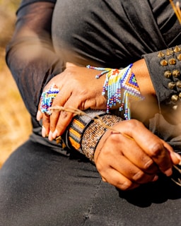 Woman wearing colorful beaded bracelets and rings