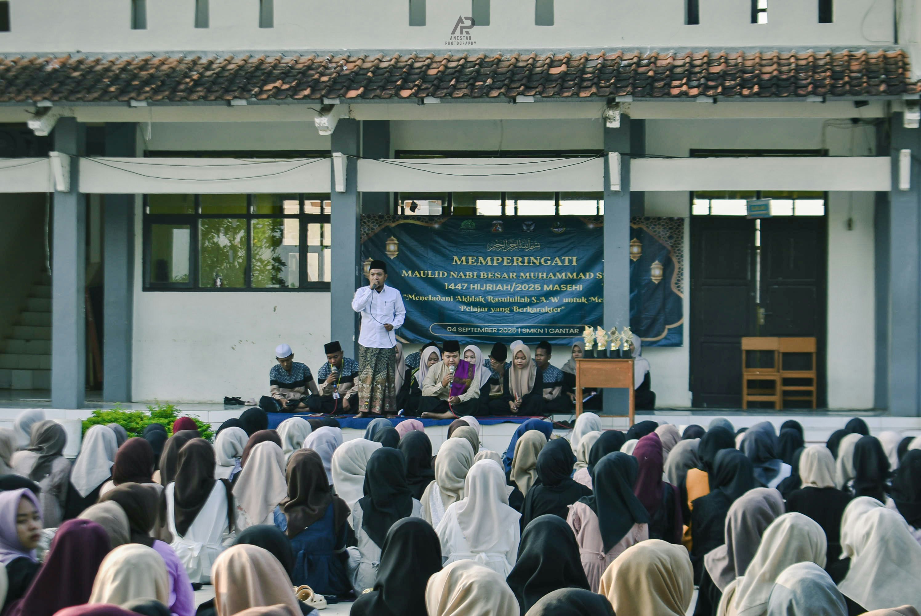 Man speaking to a crowd gathered outdoors
