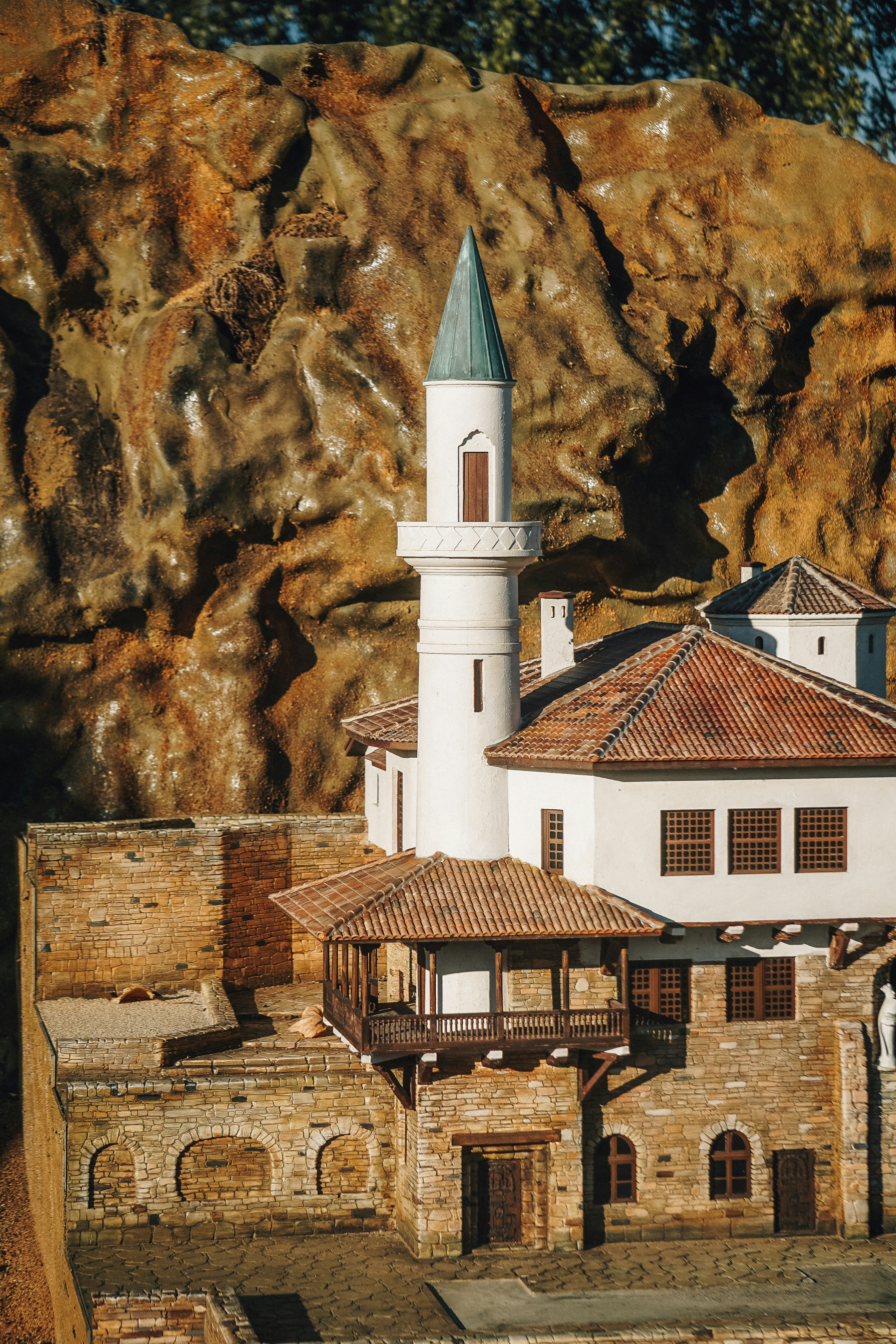 Miniature mosque and buildings against rocky backdrop
