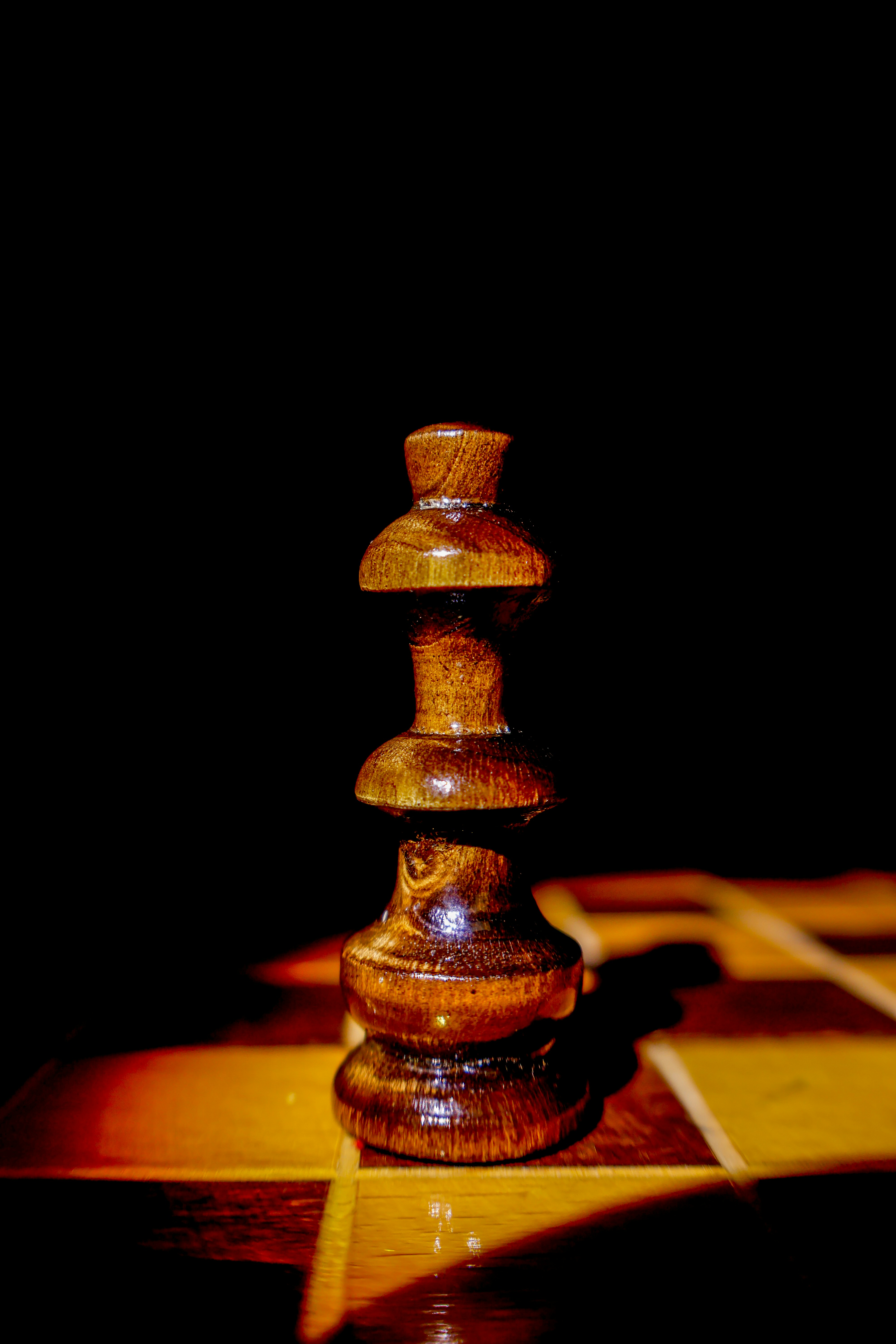 A single wooden chess piece on a chessboard