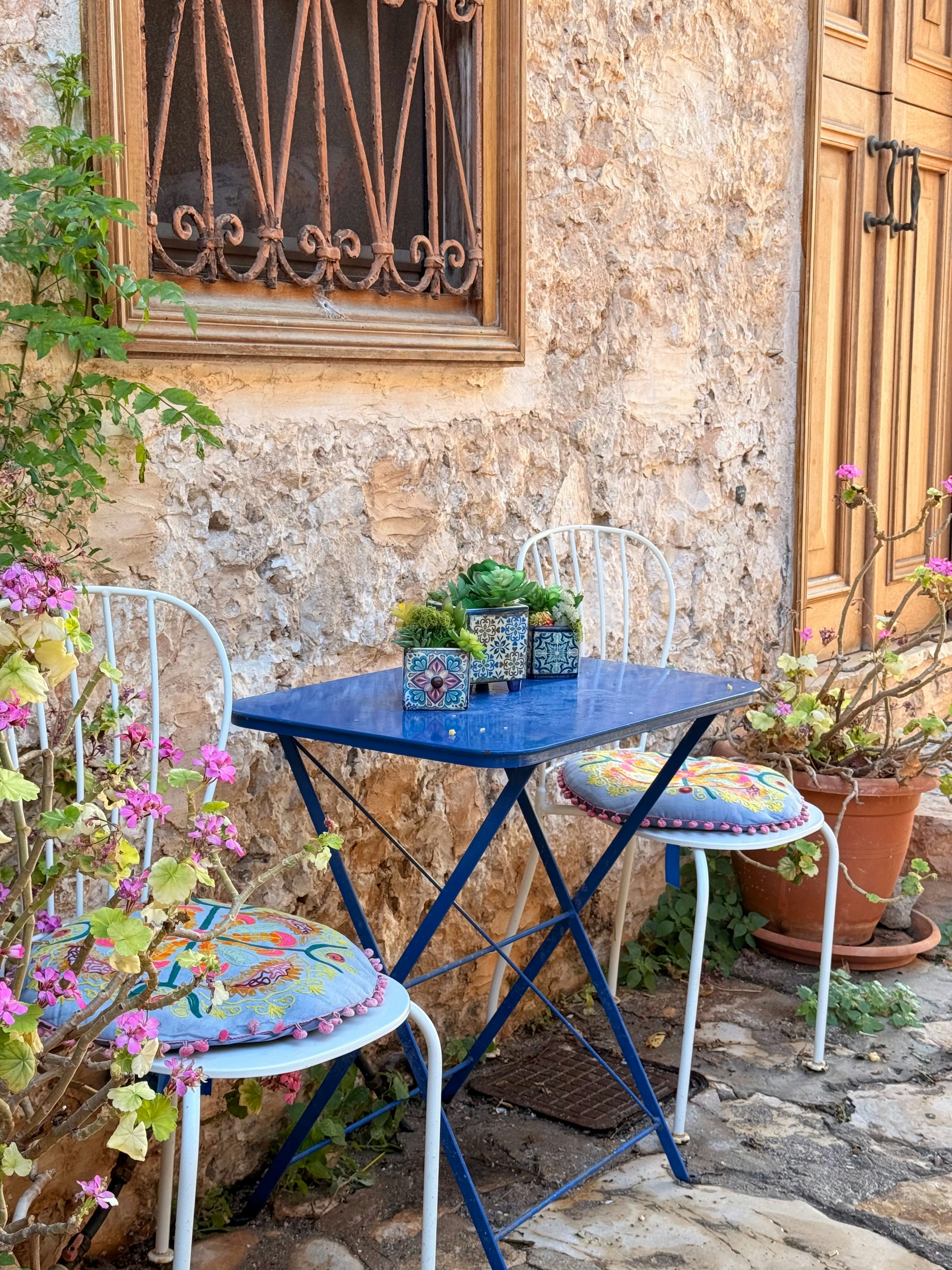 A small blue table and chairs on a patio.