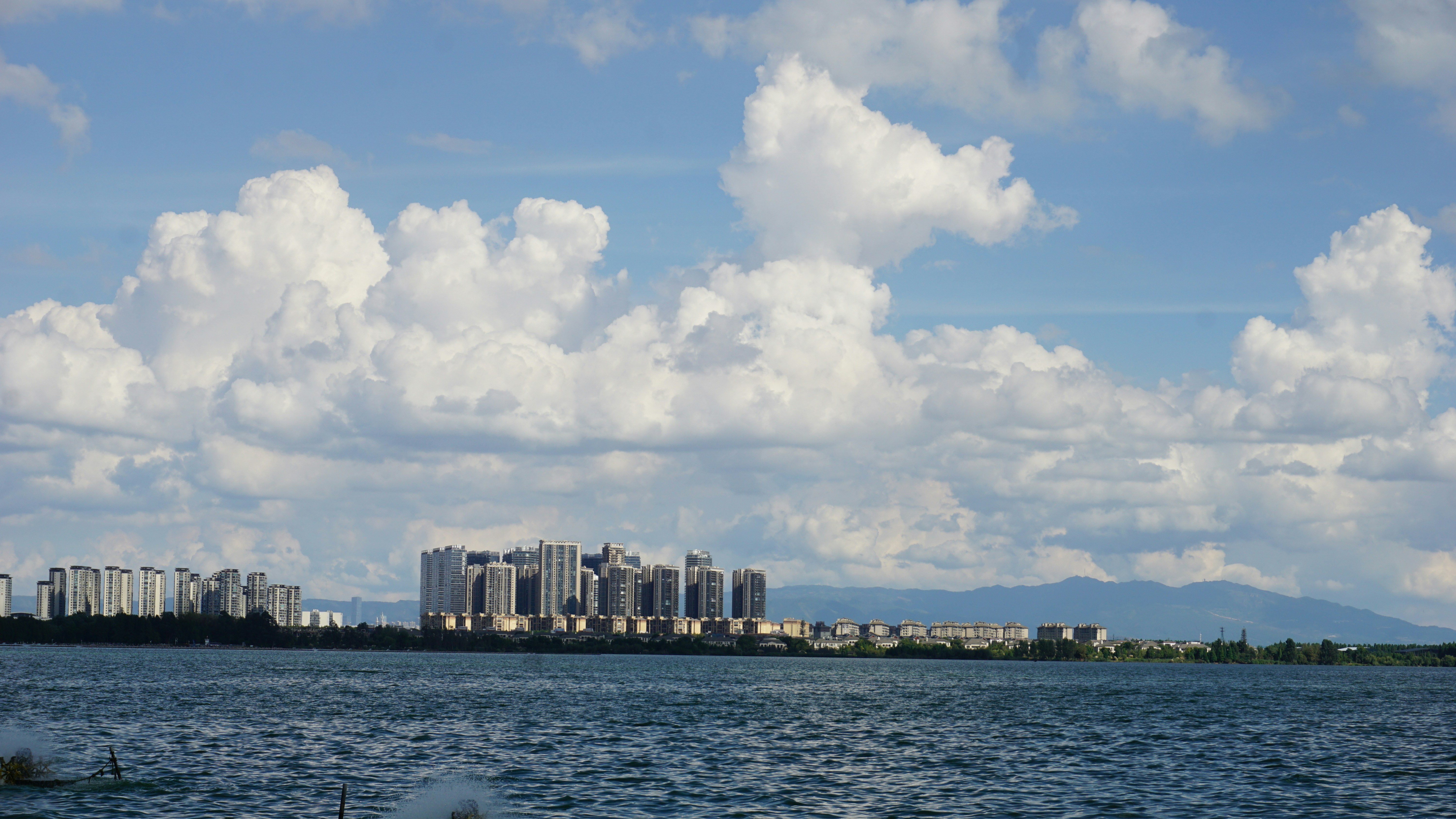 Modern buildings on the coast under a cloudy sky.