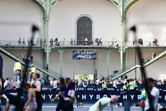 People gathered inside a large building with balconies.