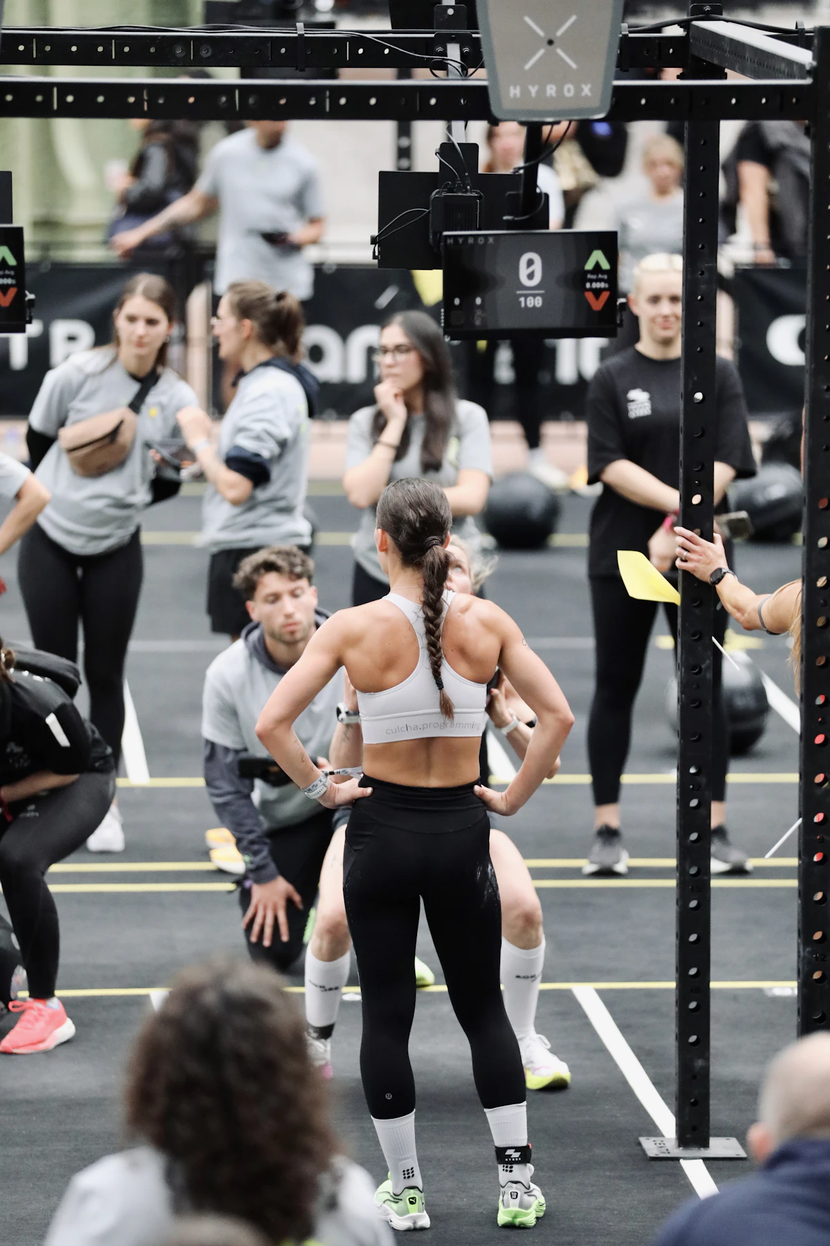 Athletes preparing for a Hyrox fitness competition on the arena floor