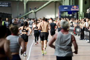 Athletes running in an indoor race event.