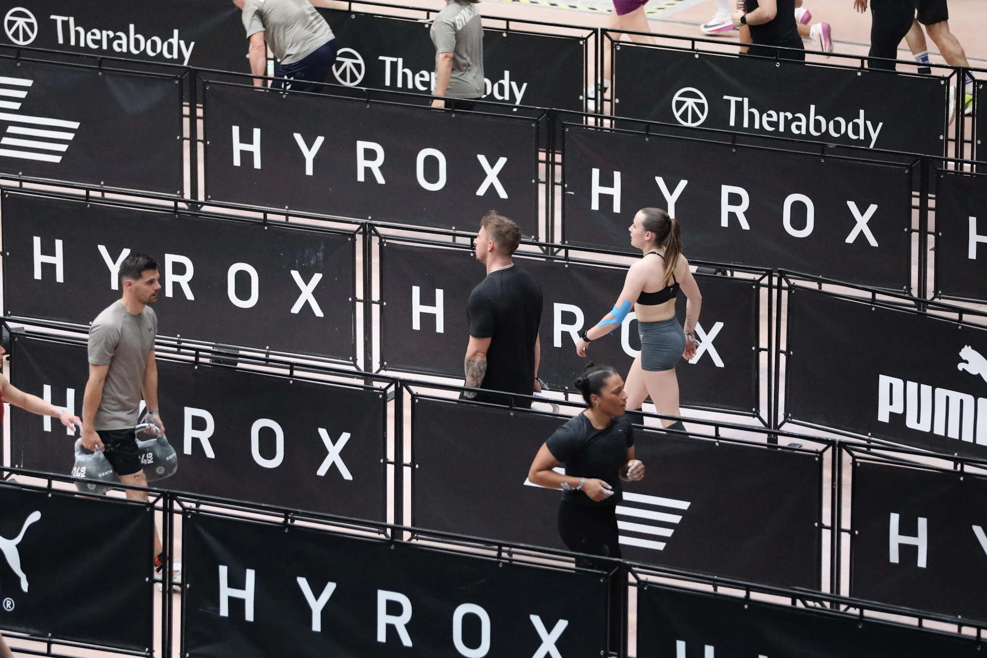 Athletes compete in a hyrox event with puma branding.