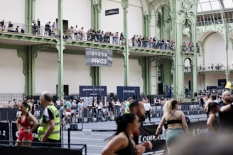 Athletes compete in an indoor sporting event with spectators watching.