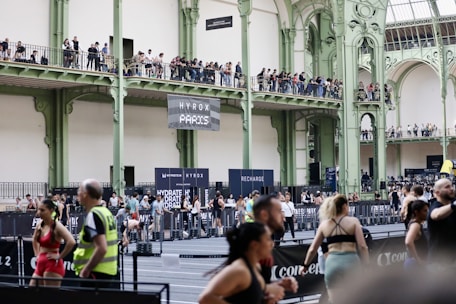 Athletes compete in an indoor sporting event with spectators watching.