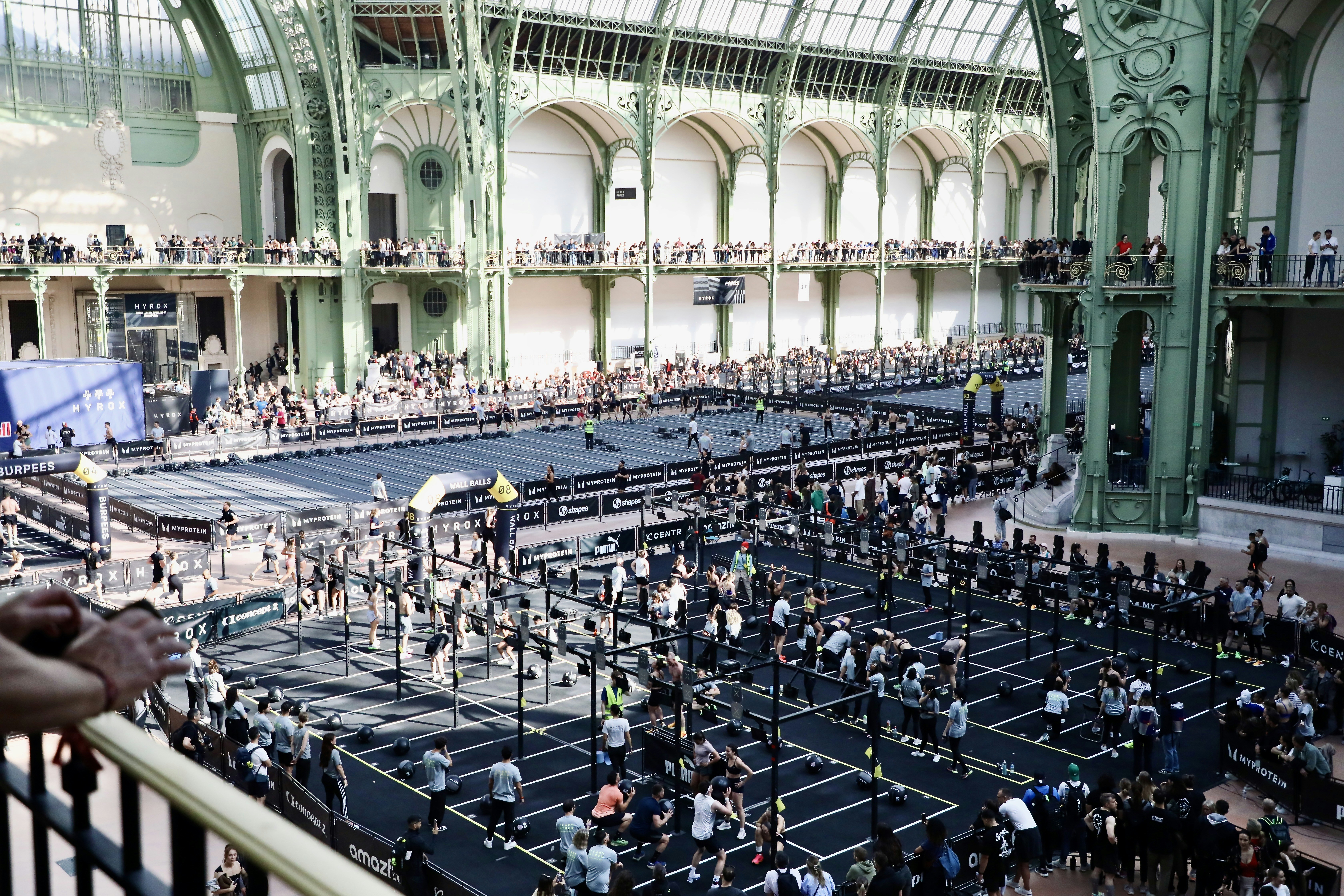 Large indoor venue with many people and rows of tables.
