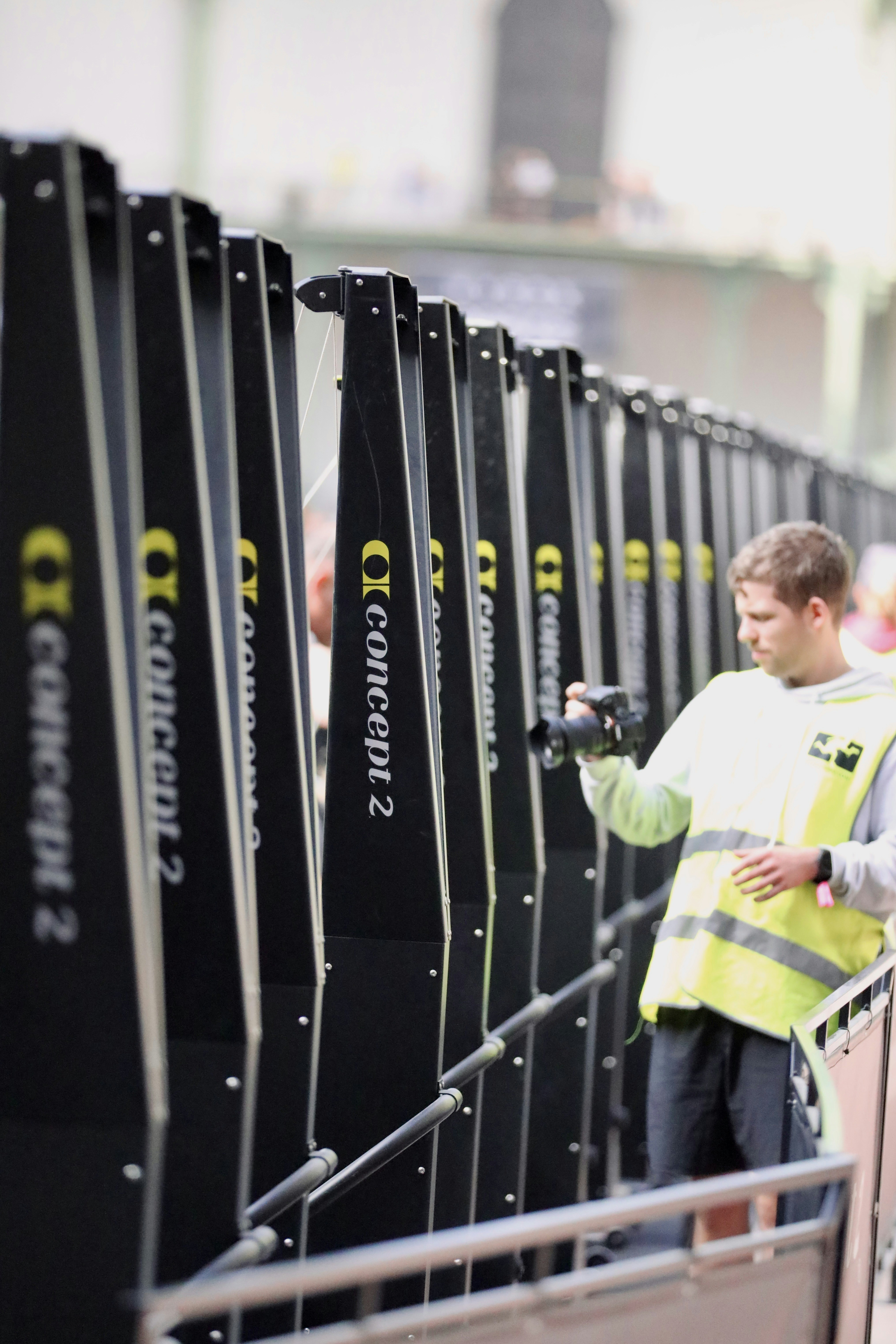Man with camera filming along a row of signs.