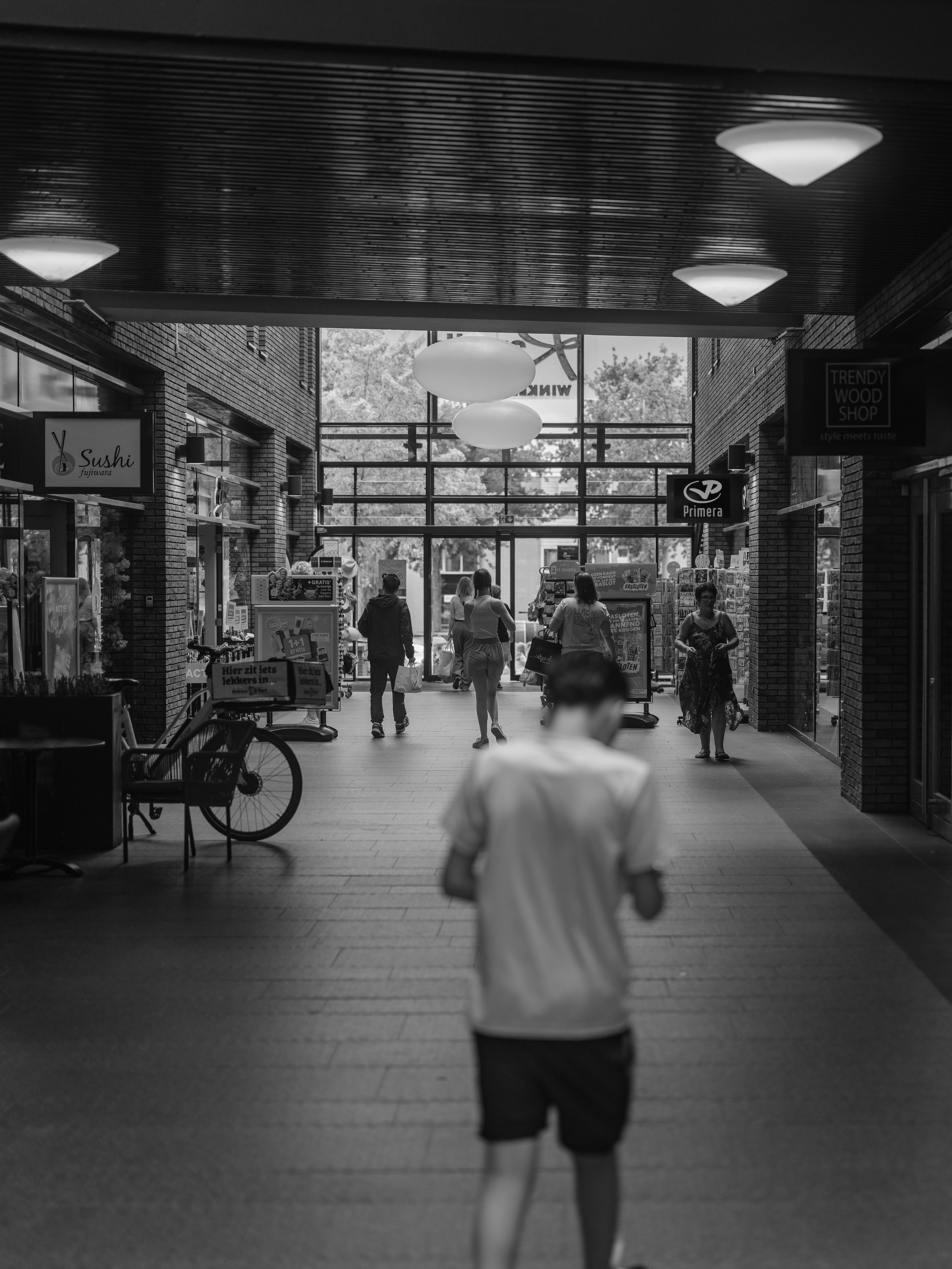 People walking through a covered outdoor walkway.