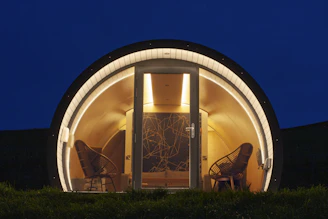 Cozy glamping pod with chairs at night
