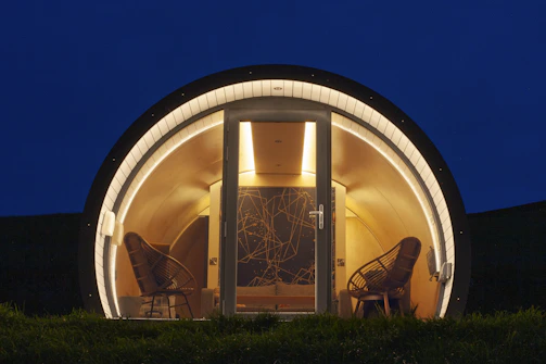 Cozy glamping pod with chairs at night