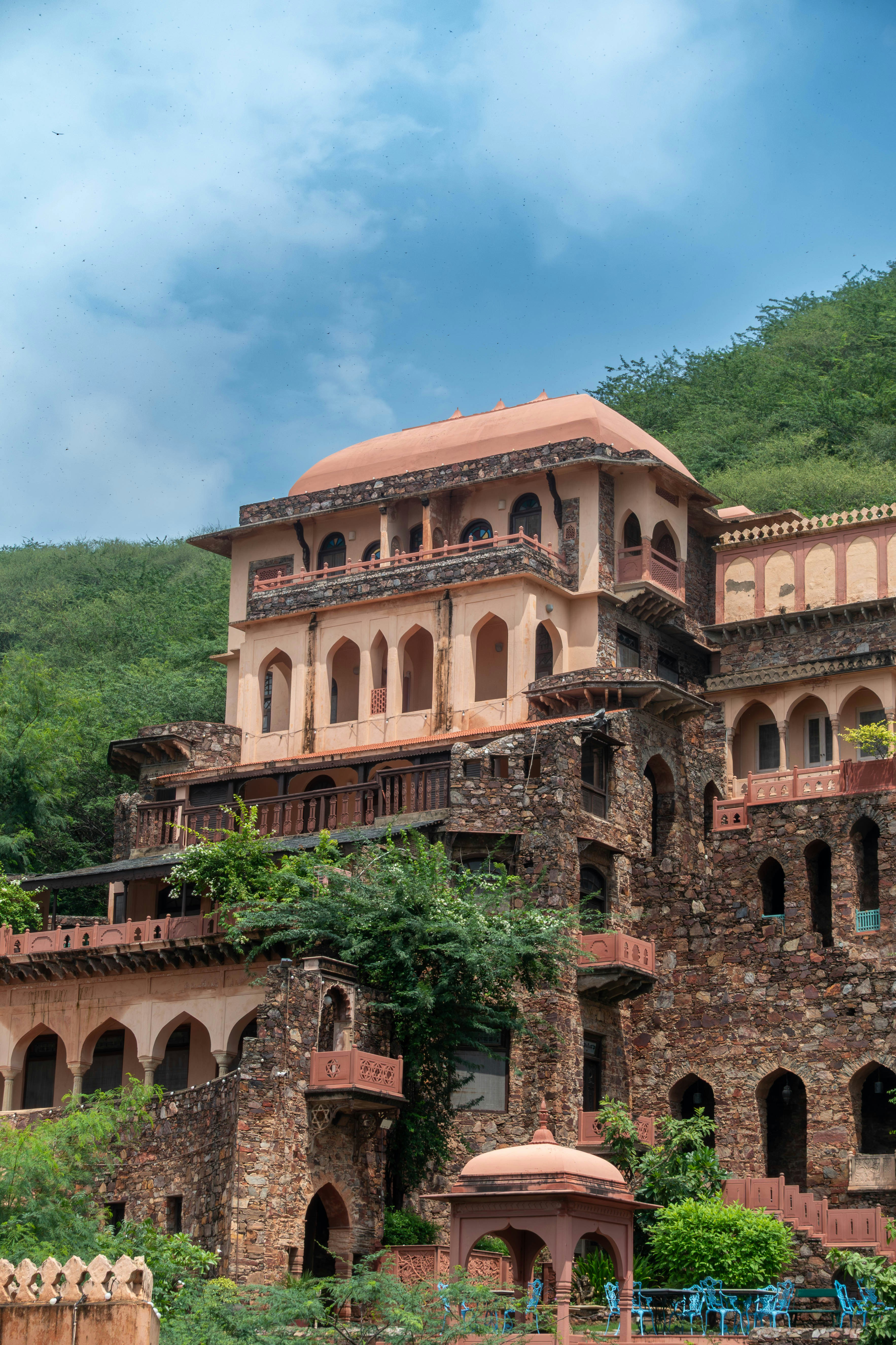 緑豊かな丘の中腹に佇む古代の石造りの建物。