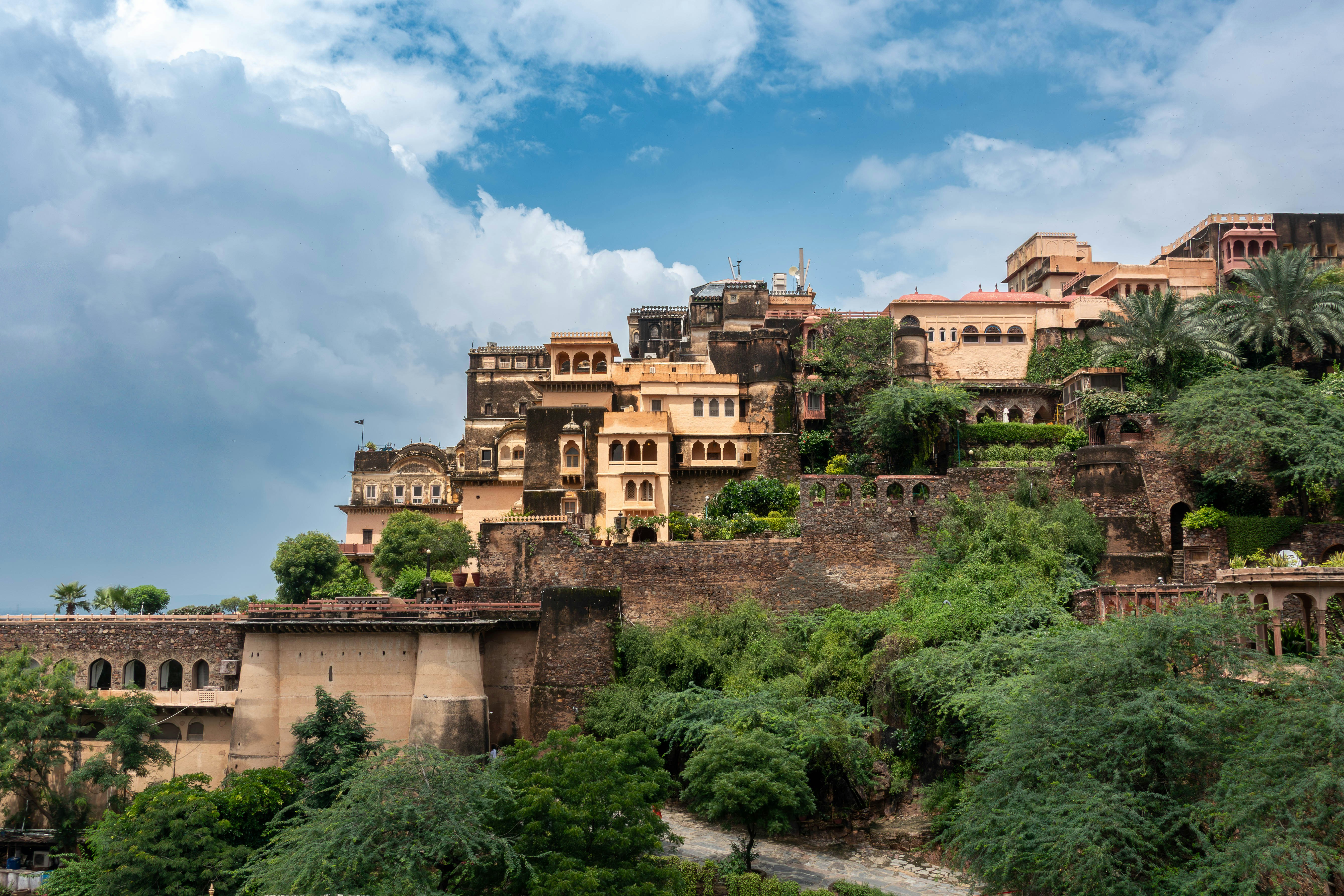 緑豊かな丘の中腹に佇む古代インドの砦の建物。