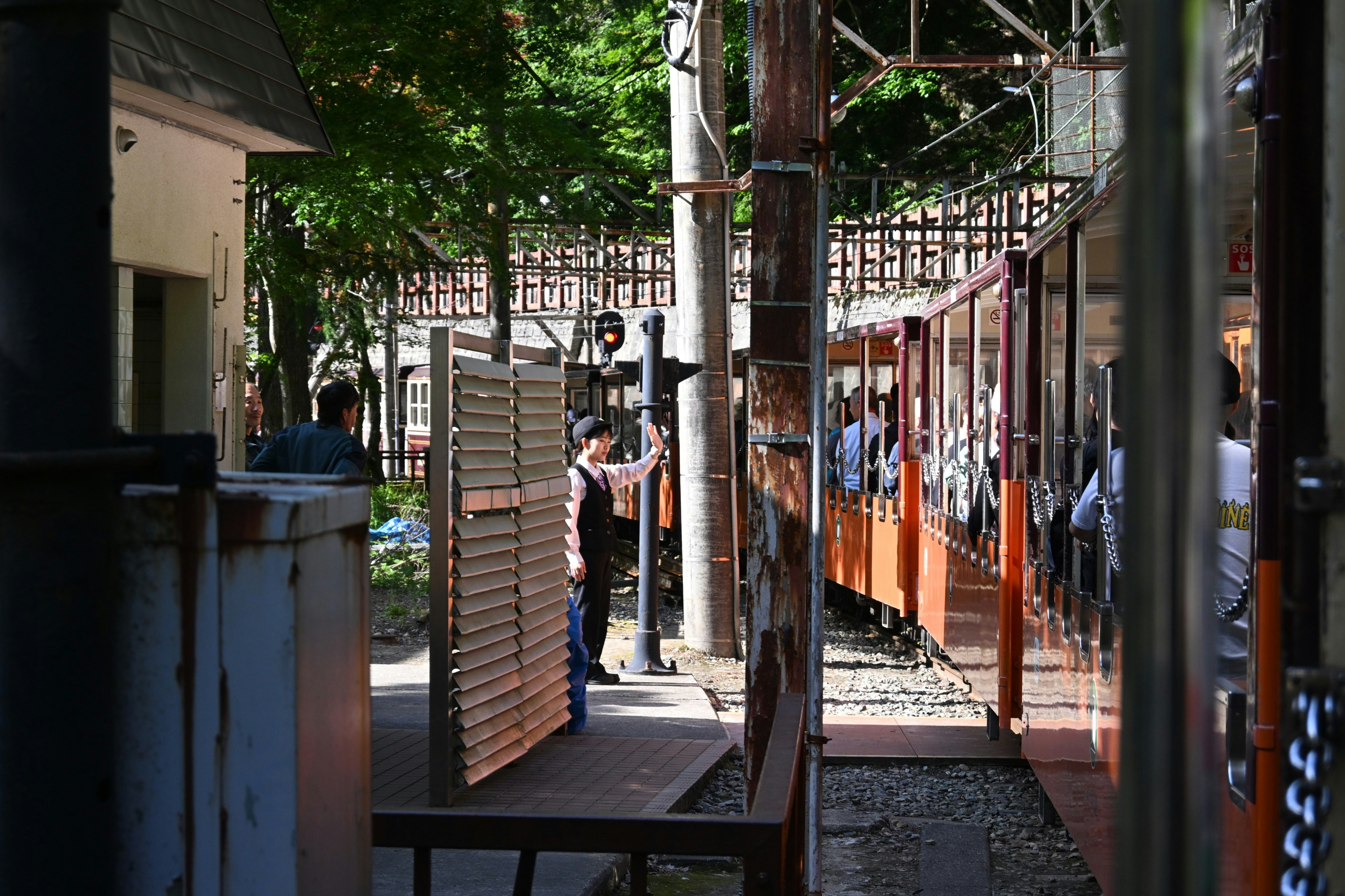 People board a vintage train at a station.