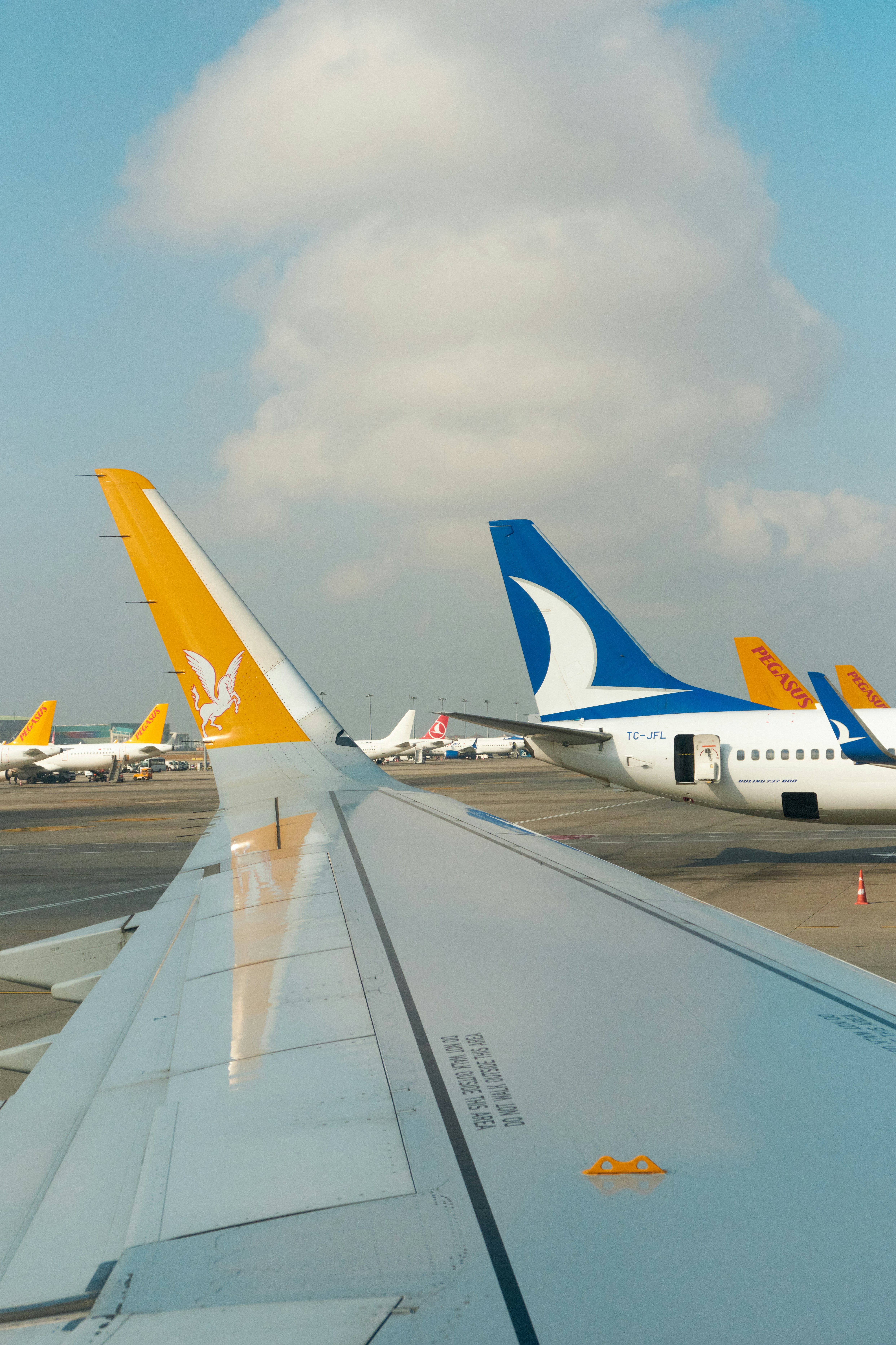 Airplane wings and tails at an airport tarmac.