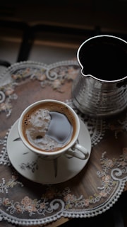 A cup of coffee and a cezve on a tray