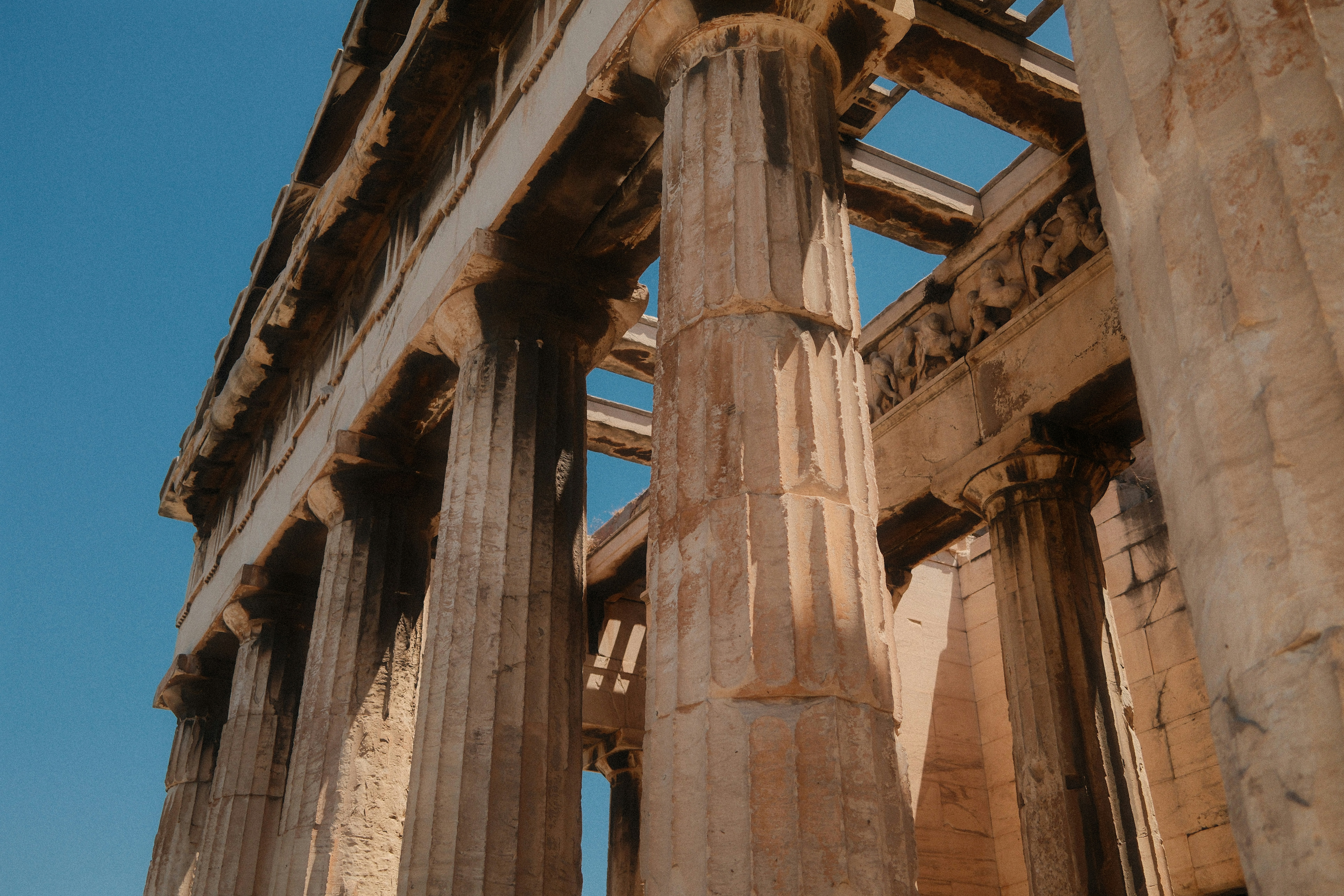 Ancient greek temple columns against a clear blue sky