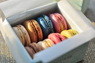 Colorful macarons arranged in a white box