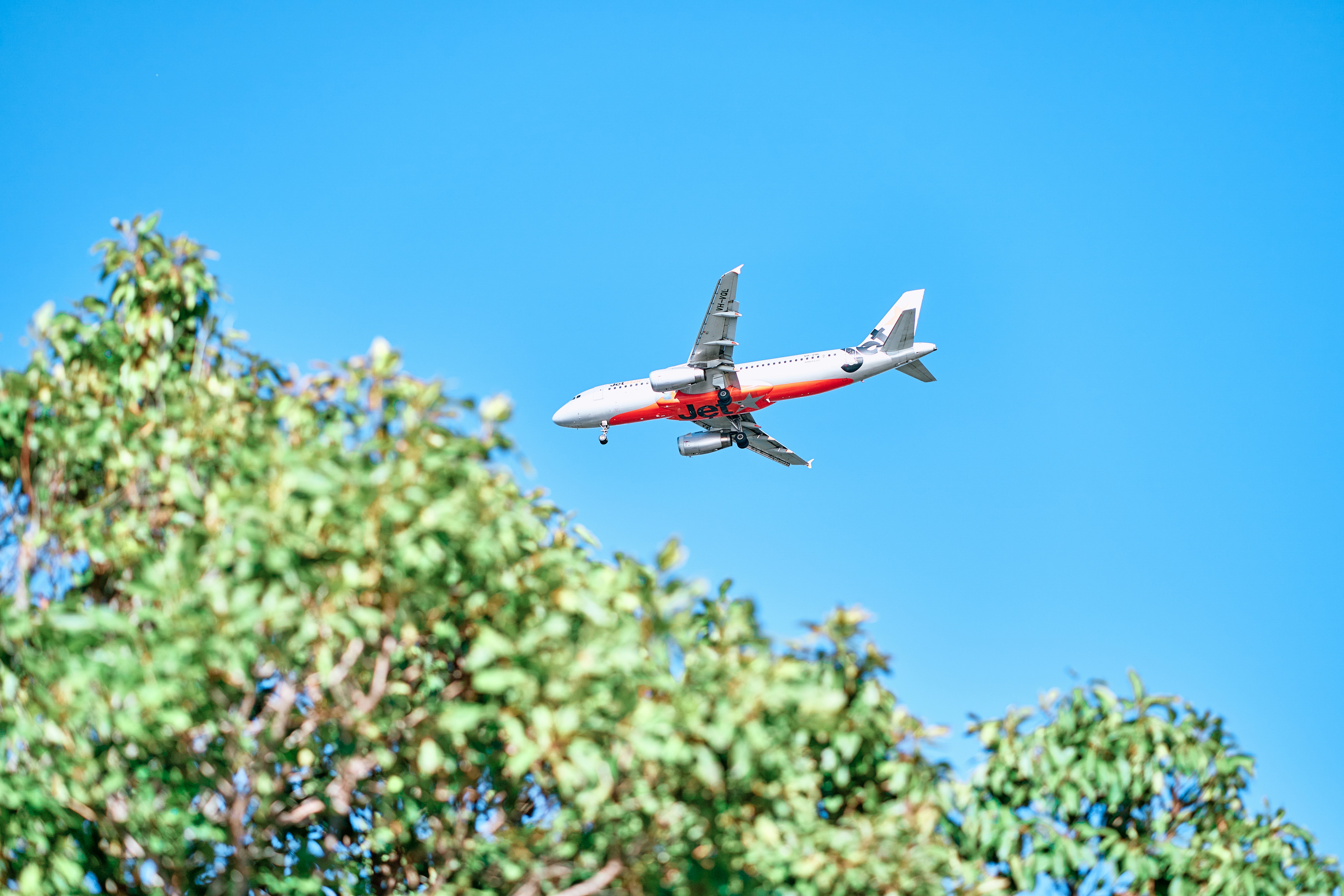An airplane flies through a clear blue sky