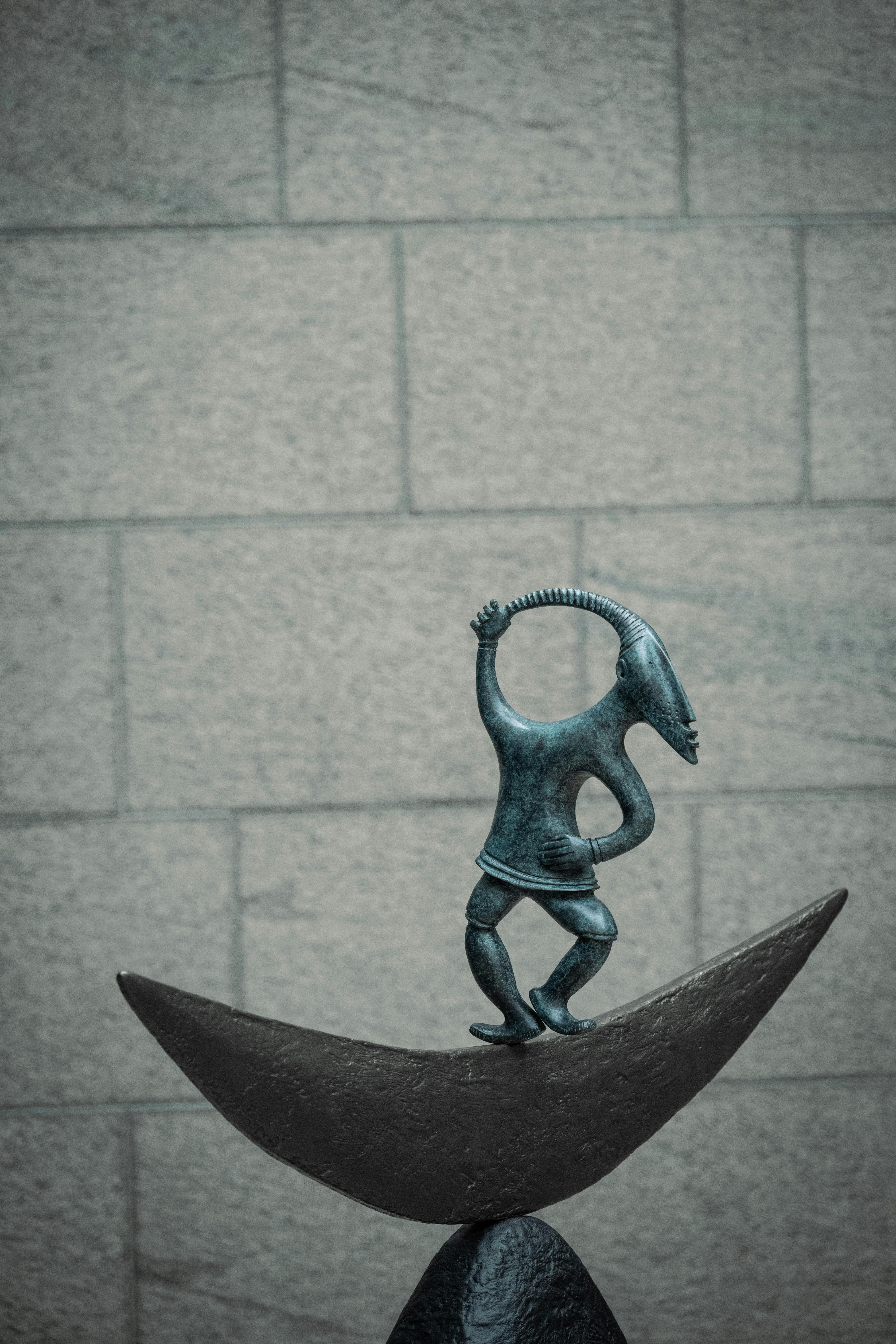 Bronze sculpture of a figure on a crescent moon