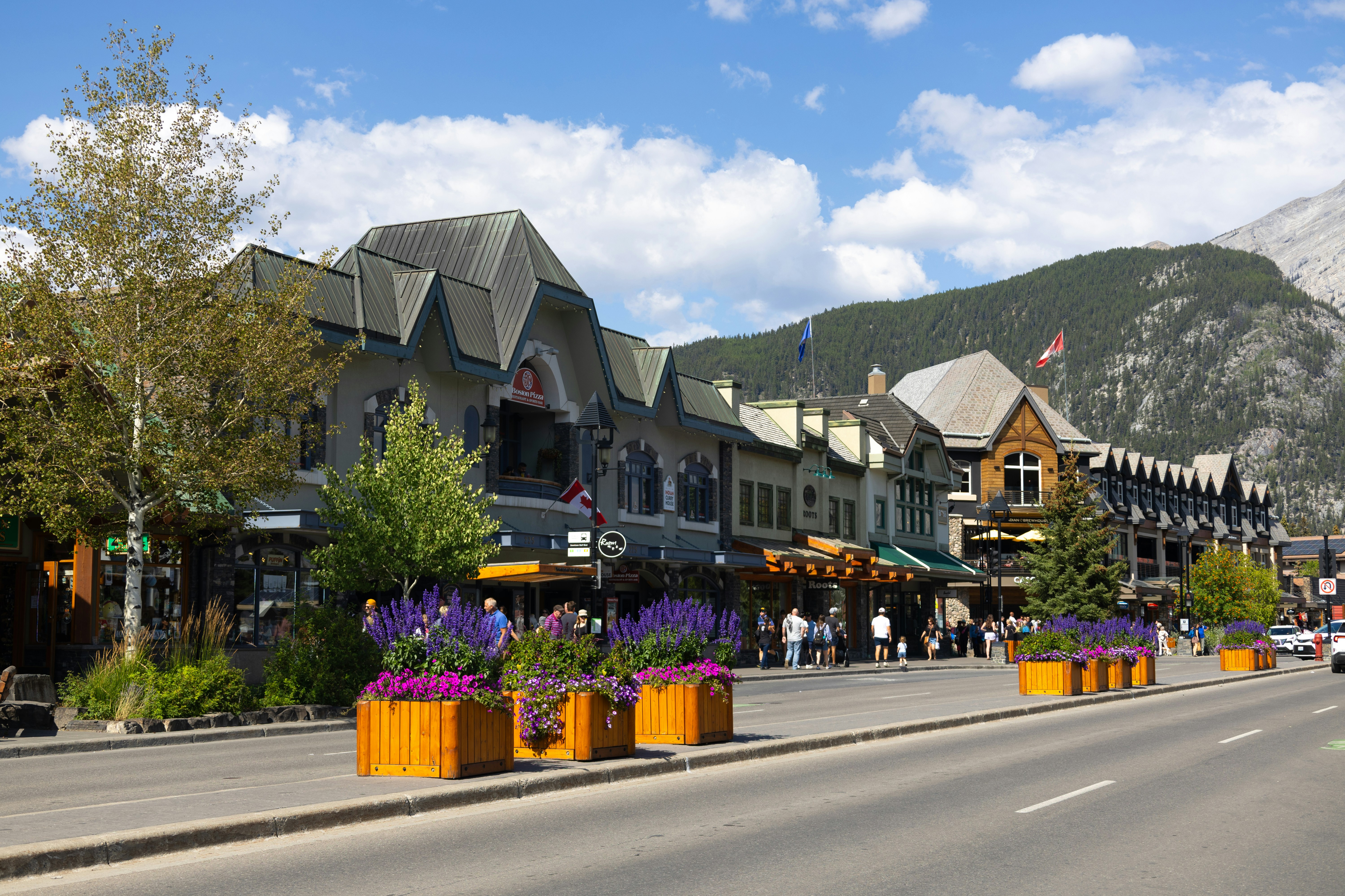Street view of shops with mountains in the background.