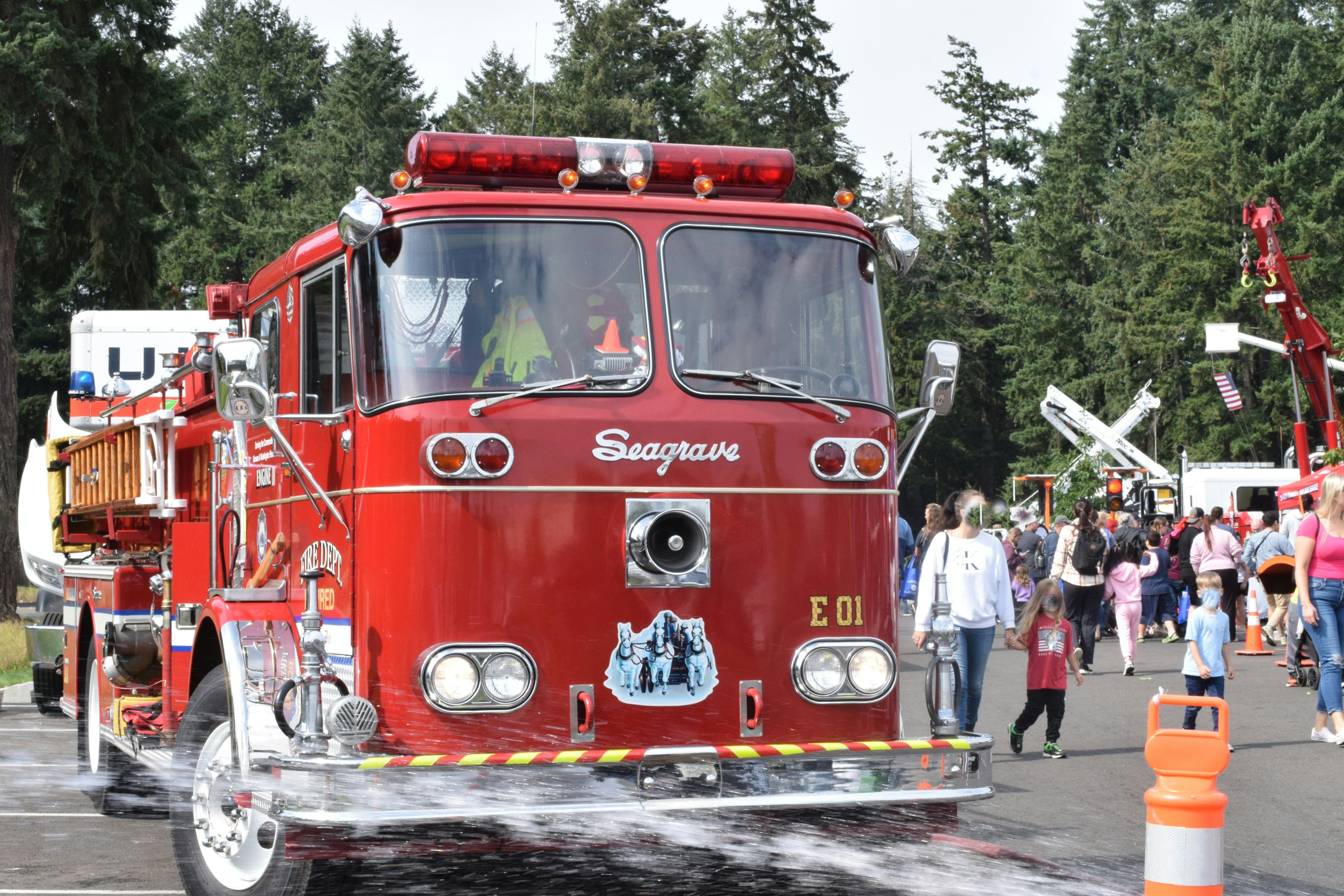 A vintage red fire truck at an outdoor event