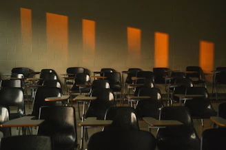 Empty classroom with sunlight shining through windows.