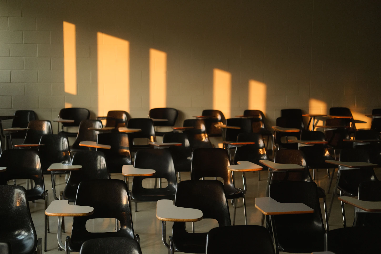 Empty classroom with sunlight casting shadows through the windows