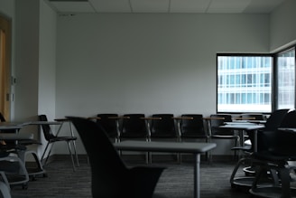Empty classroom with desks and chairs near window