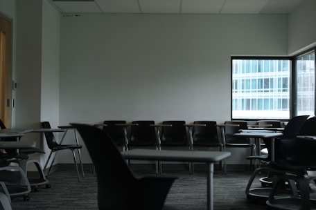 Empty classroom with desks and chairs near window