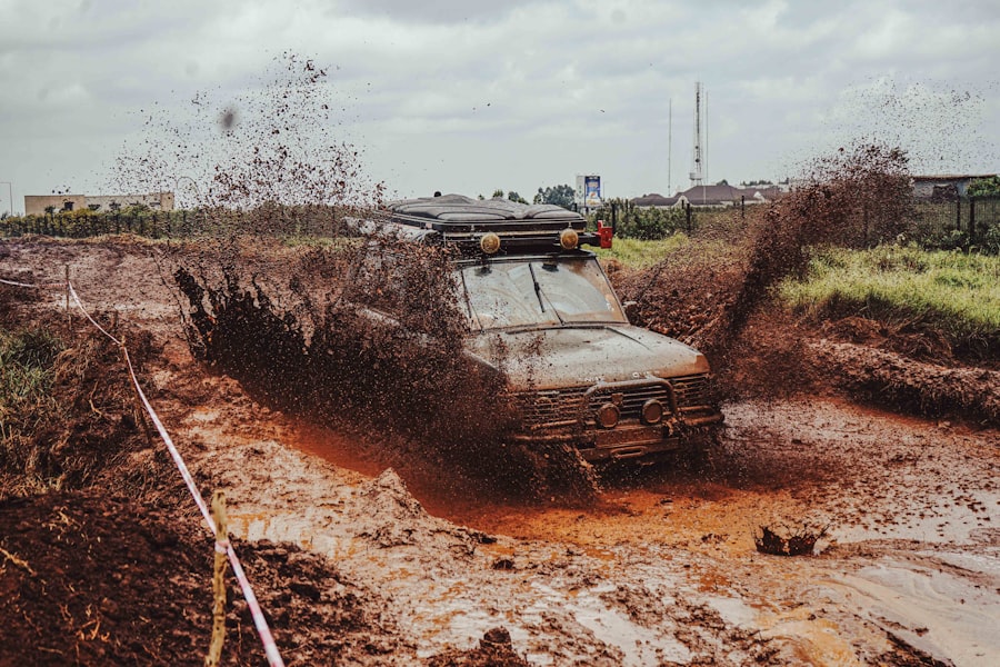 Off-road vehicle splashing through mud on a dirt track