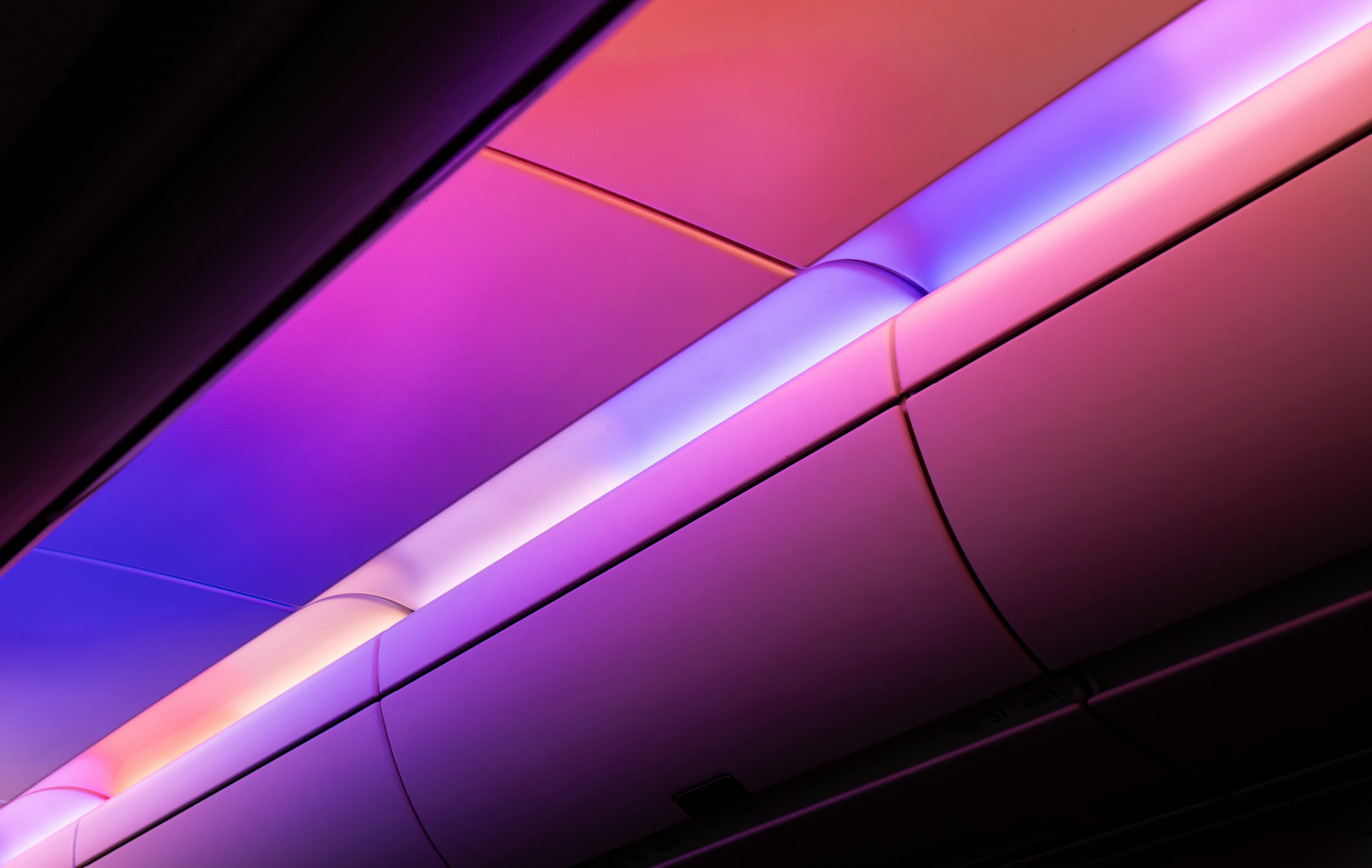 Airplane cabin ceiling with purple and pink lighting