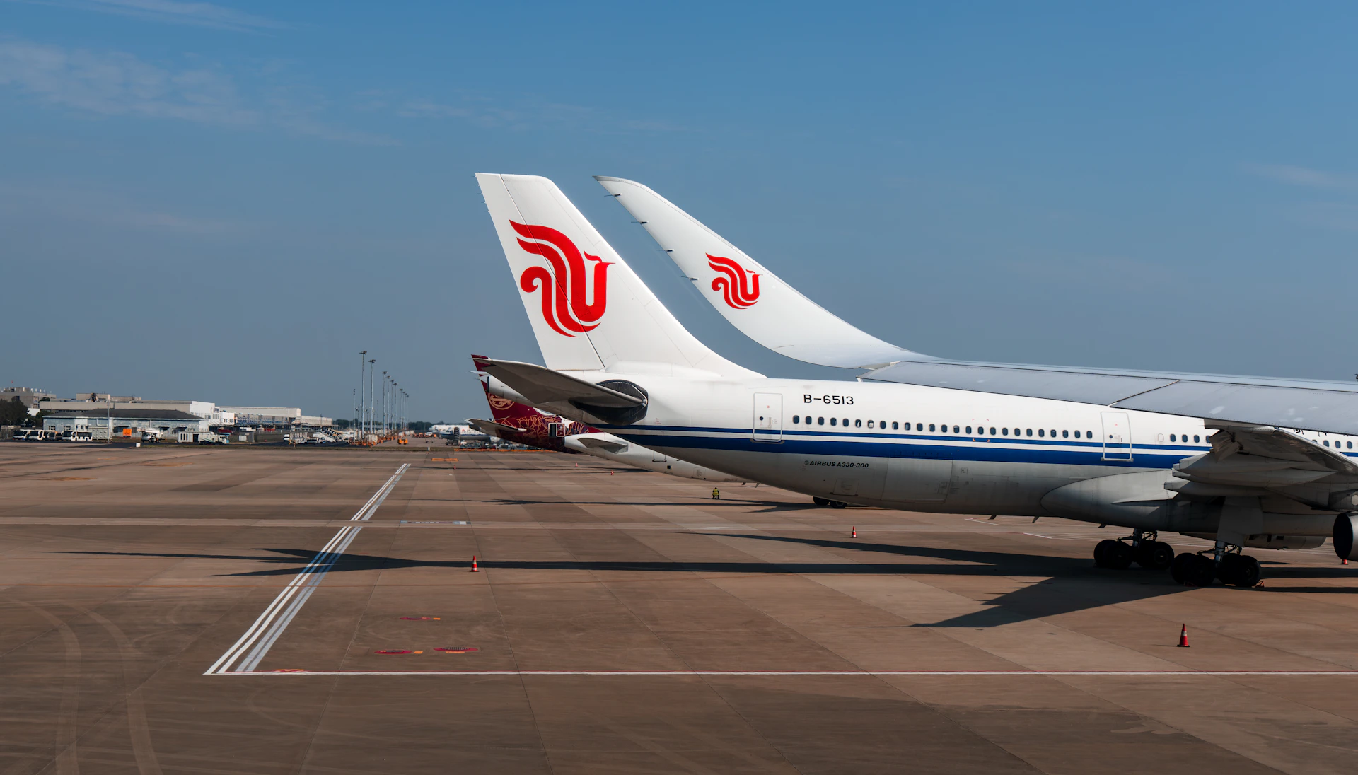 Two airplanes parked on the tarmac at an airport.