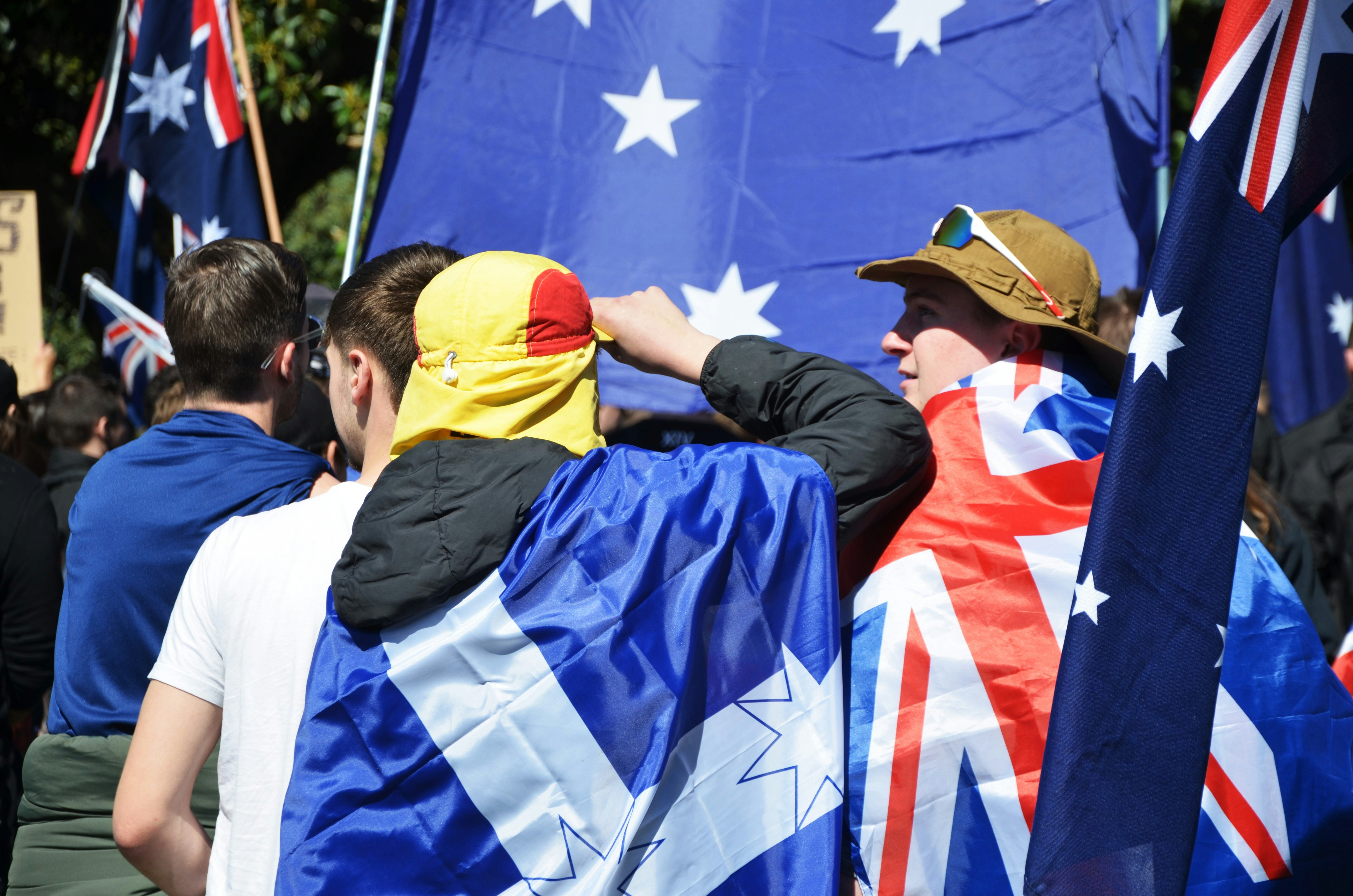 People holding australian flags at a rally.