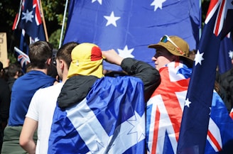 People holding australian flags at a rally.
