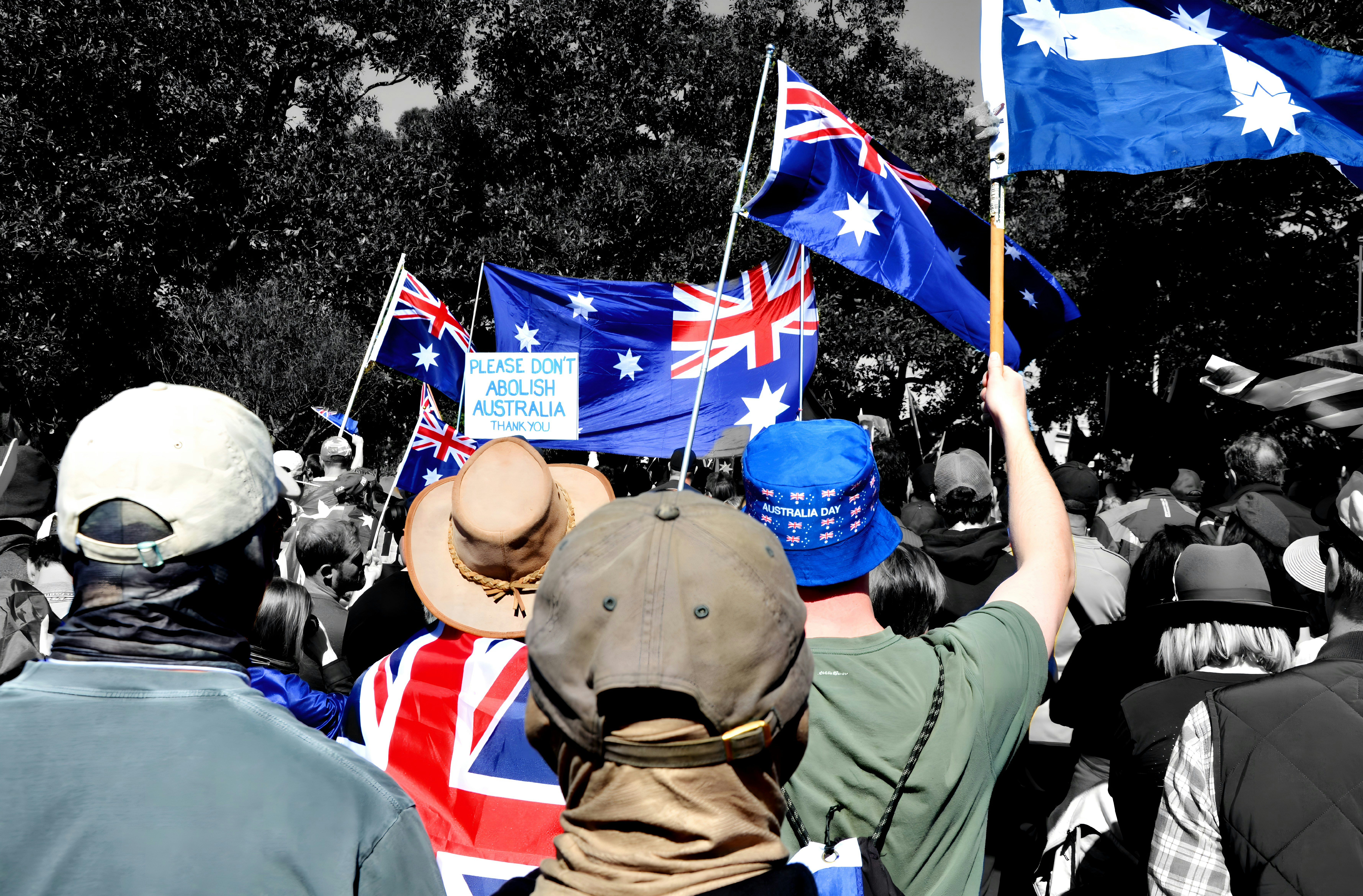 Crowd waving australian flags at a rally