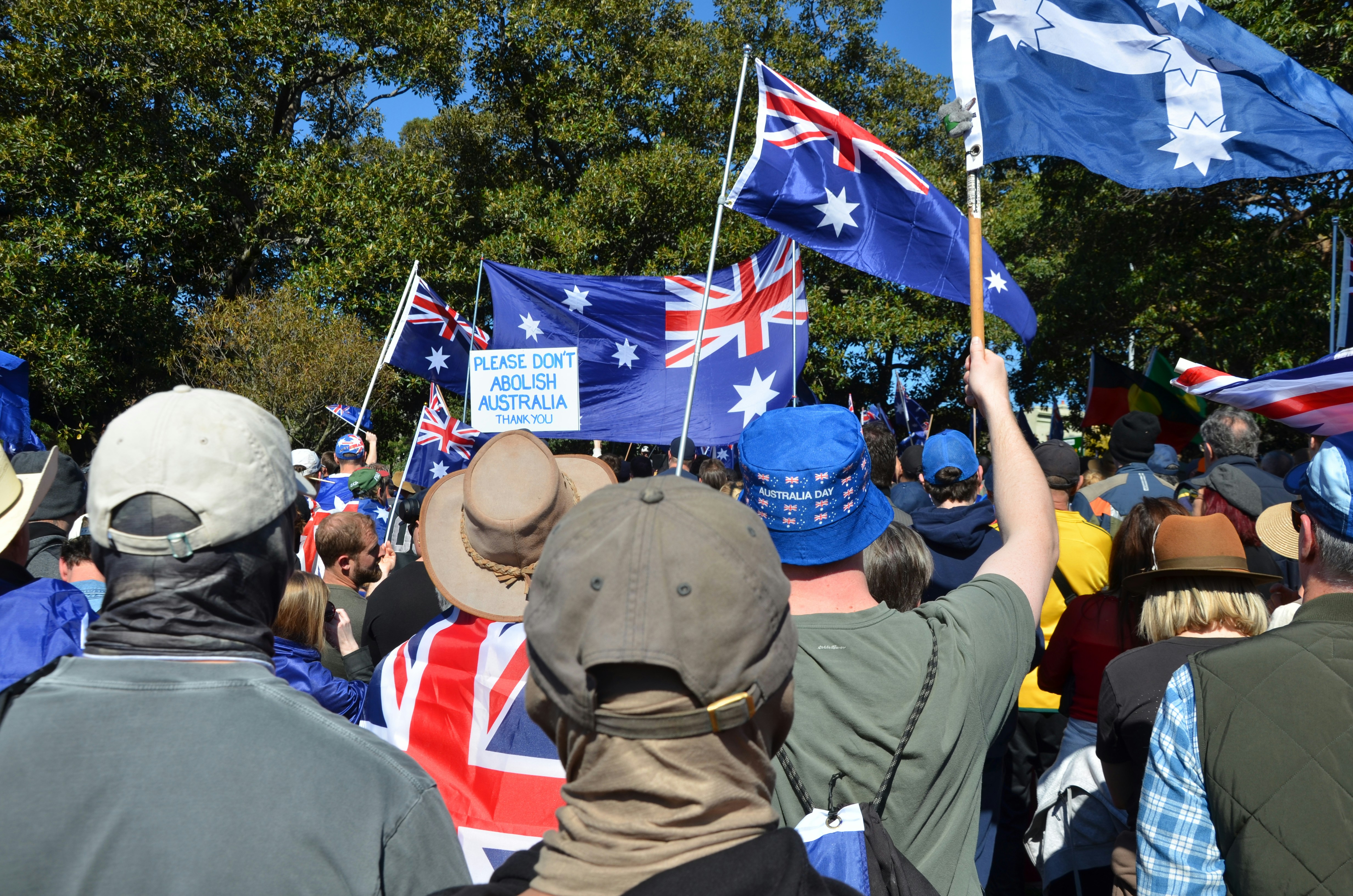 Crowd holding australian flags at a rally
