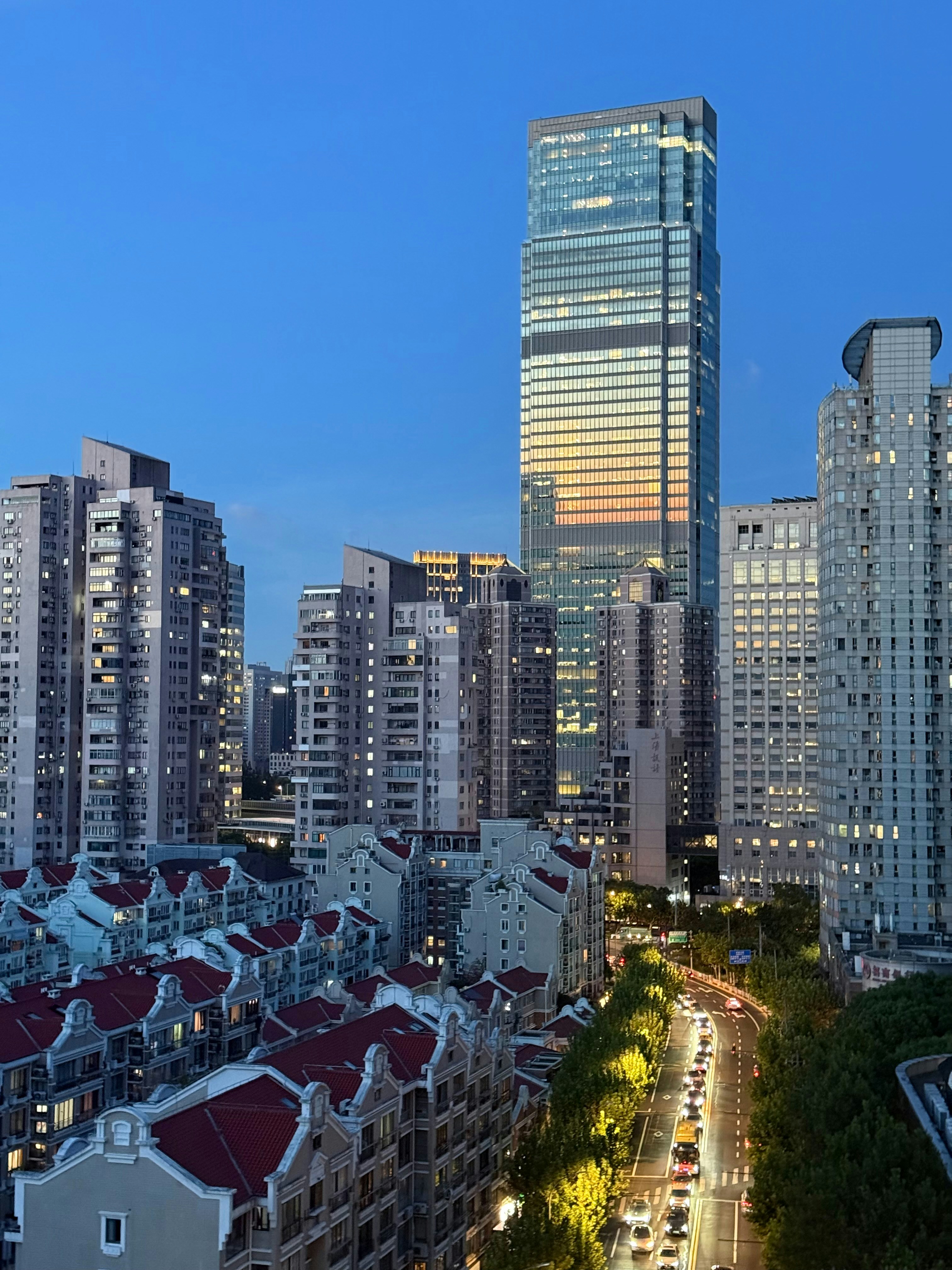 Modern cityscape with tall buildings and street lights at dusk