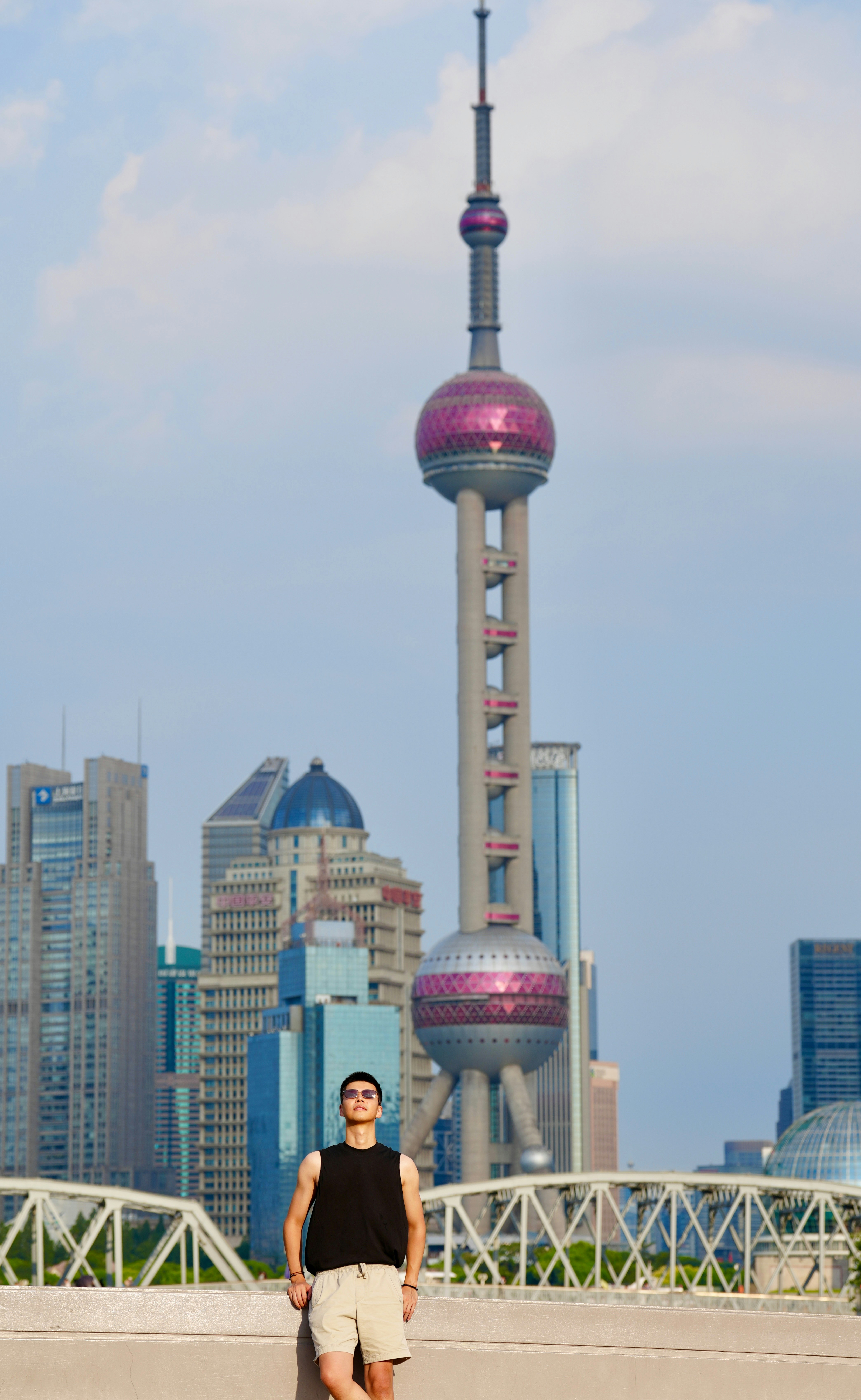 Man leaning on railing with shanghai skyline behind