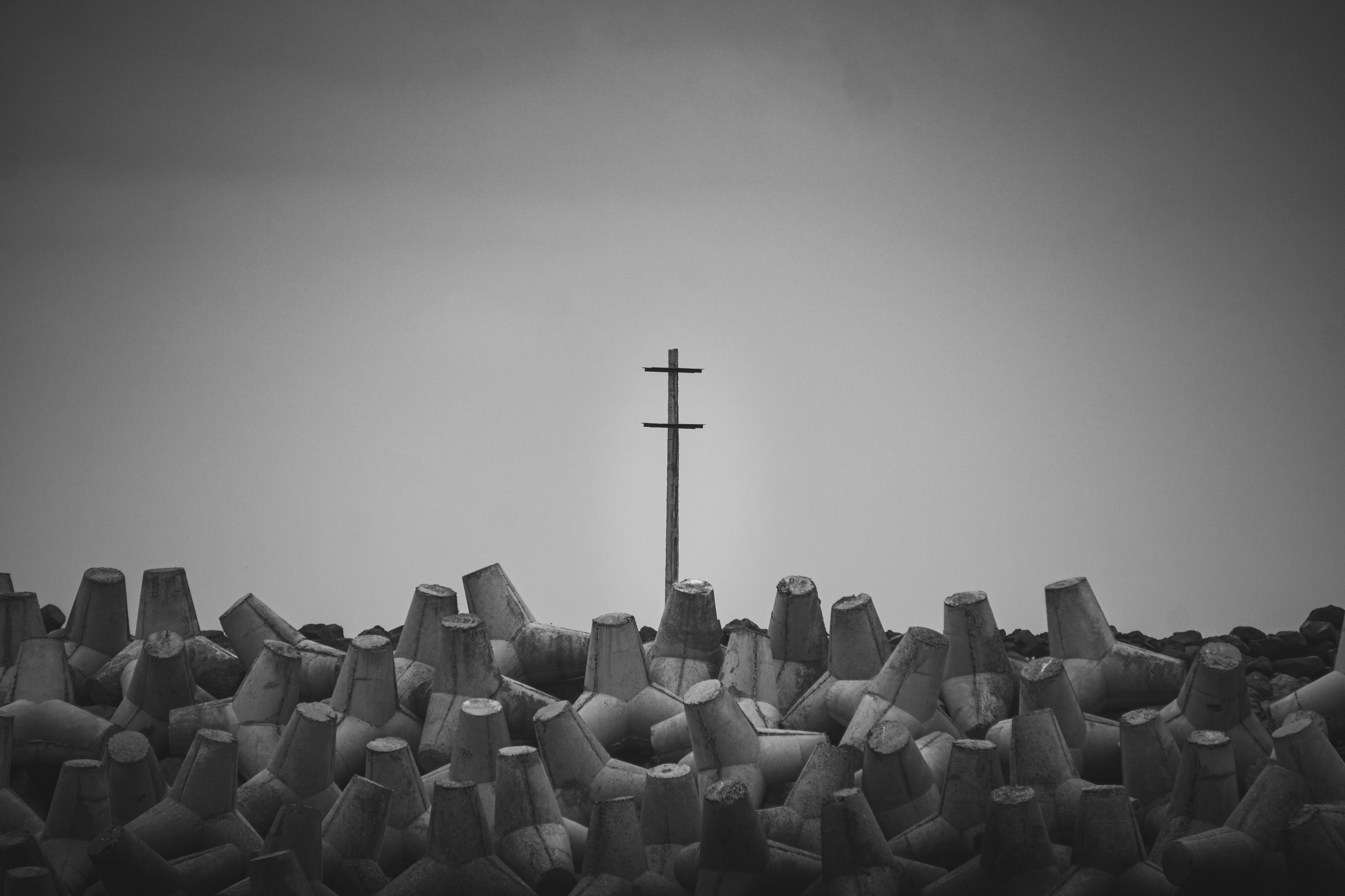 Tetrapods and telephone pole against sky