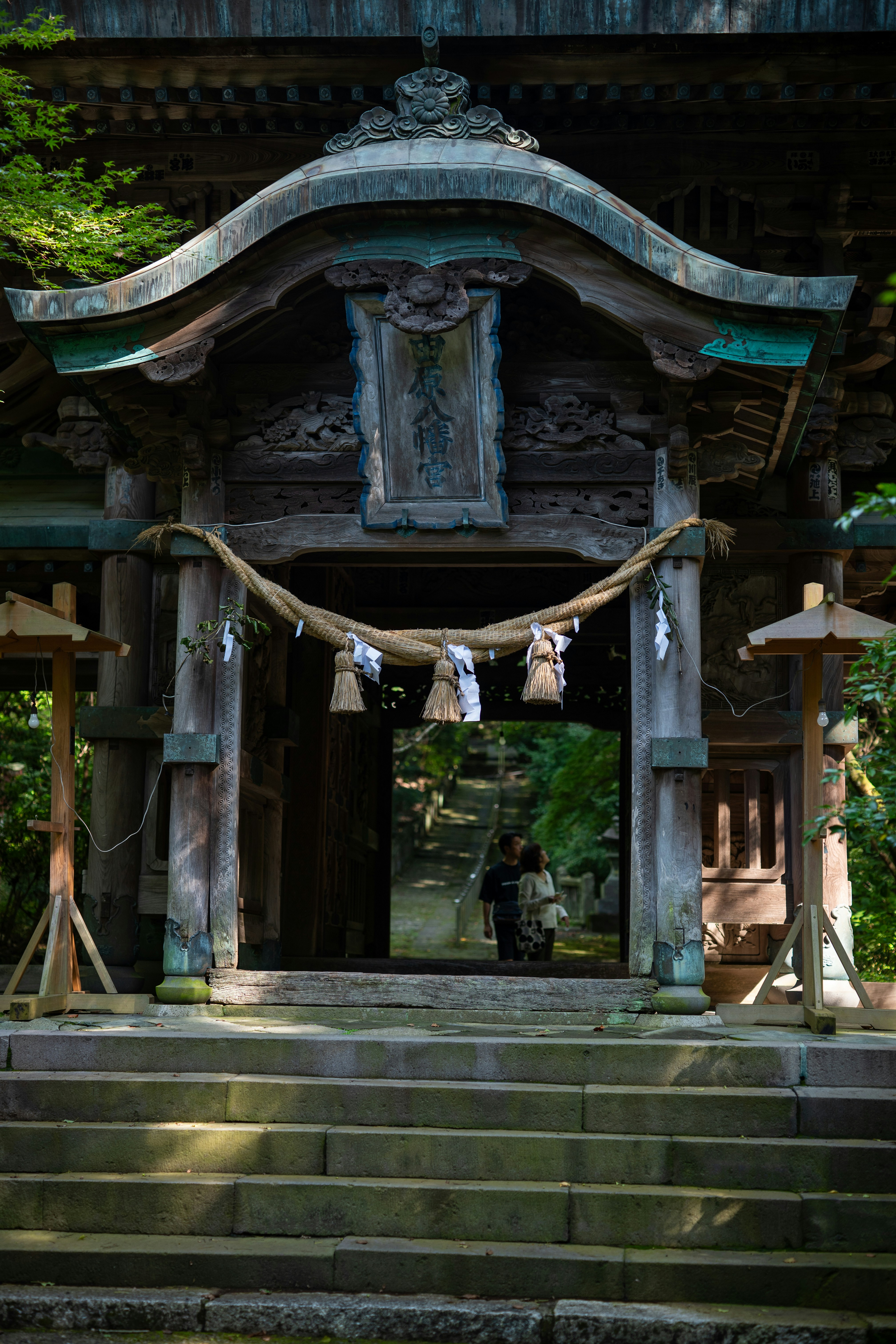 Wooden temple gate with people entering