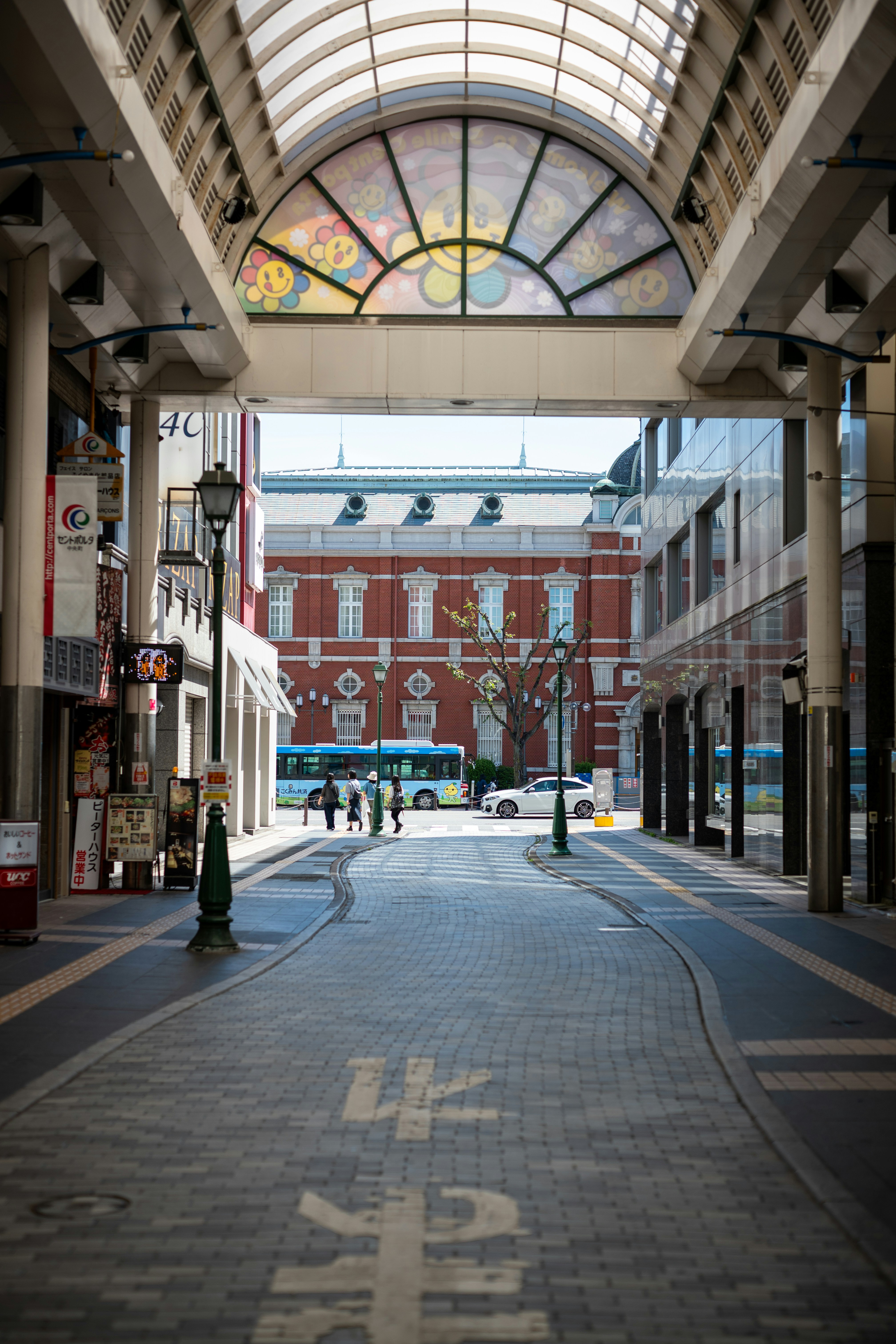 屋根付きの通りは赤レンガの建物に通じています。の写真