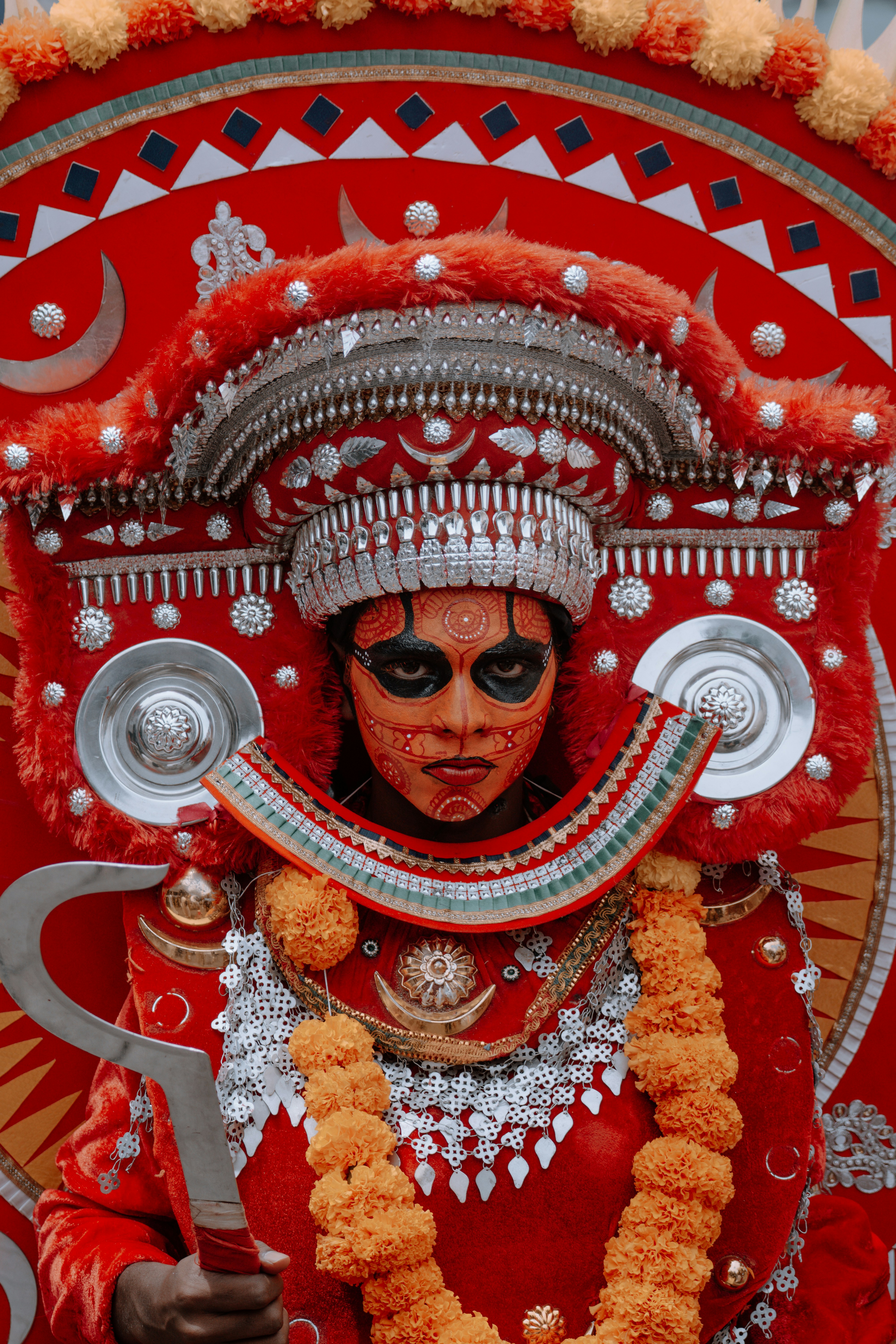 Personne en costume rouge élaboré avec peinture faciale.