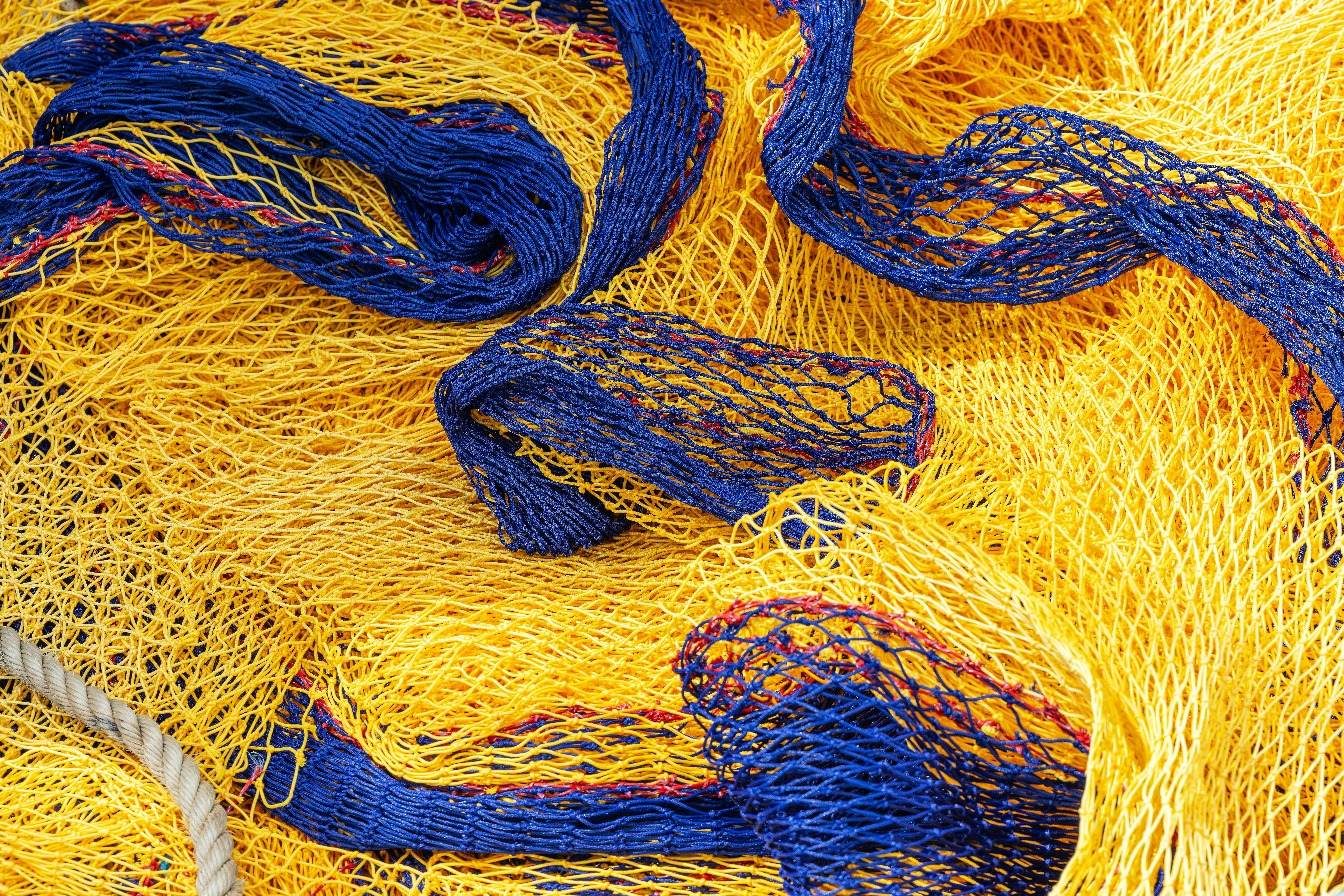 Nahaufnahme von gelben und blauen Fischernetzen