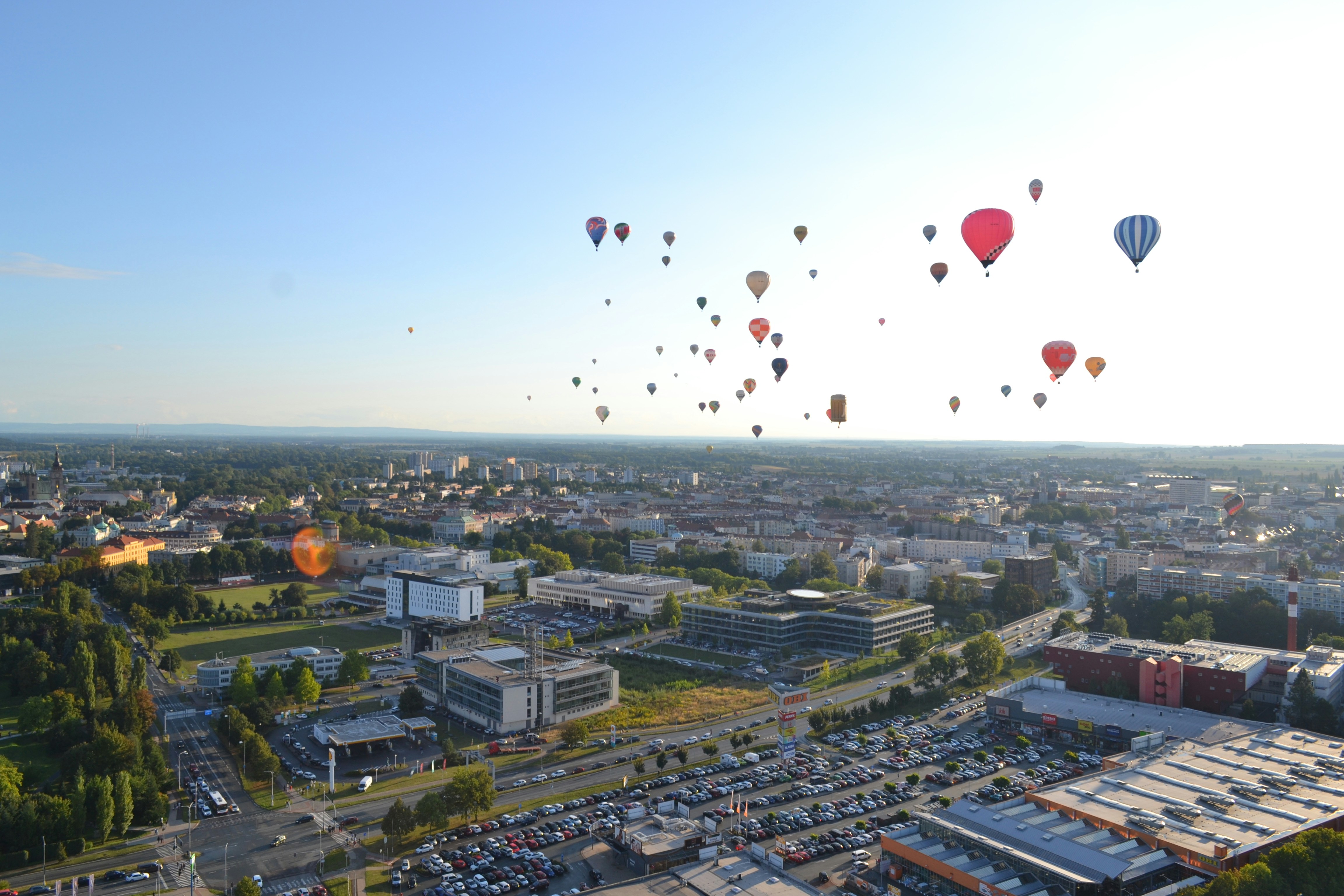 Many hot air balloons flying over a city