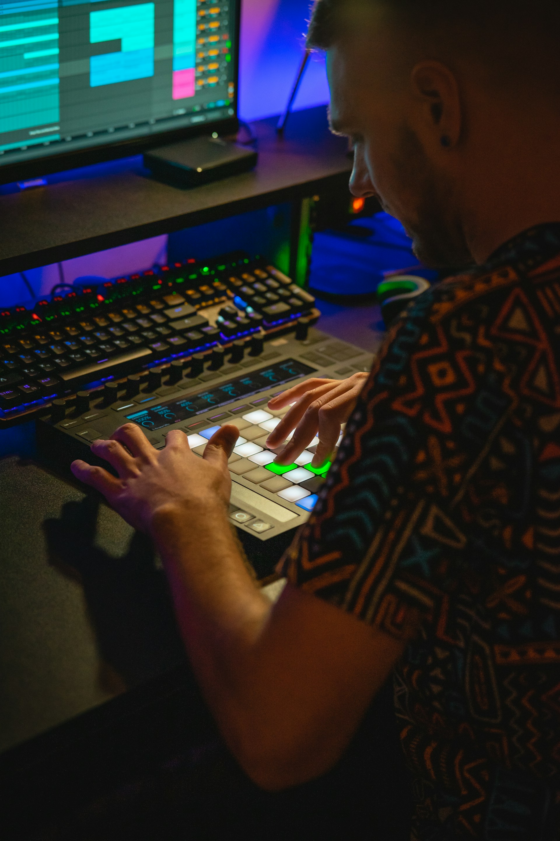 Man creating music on a controller in a studio.