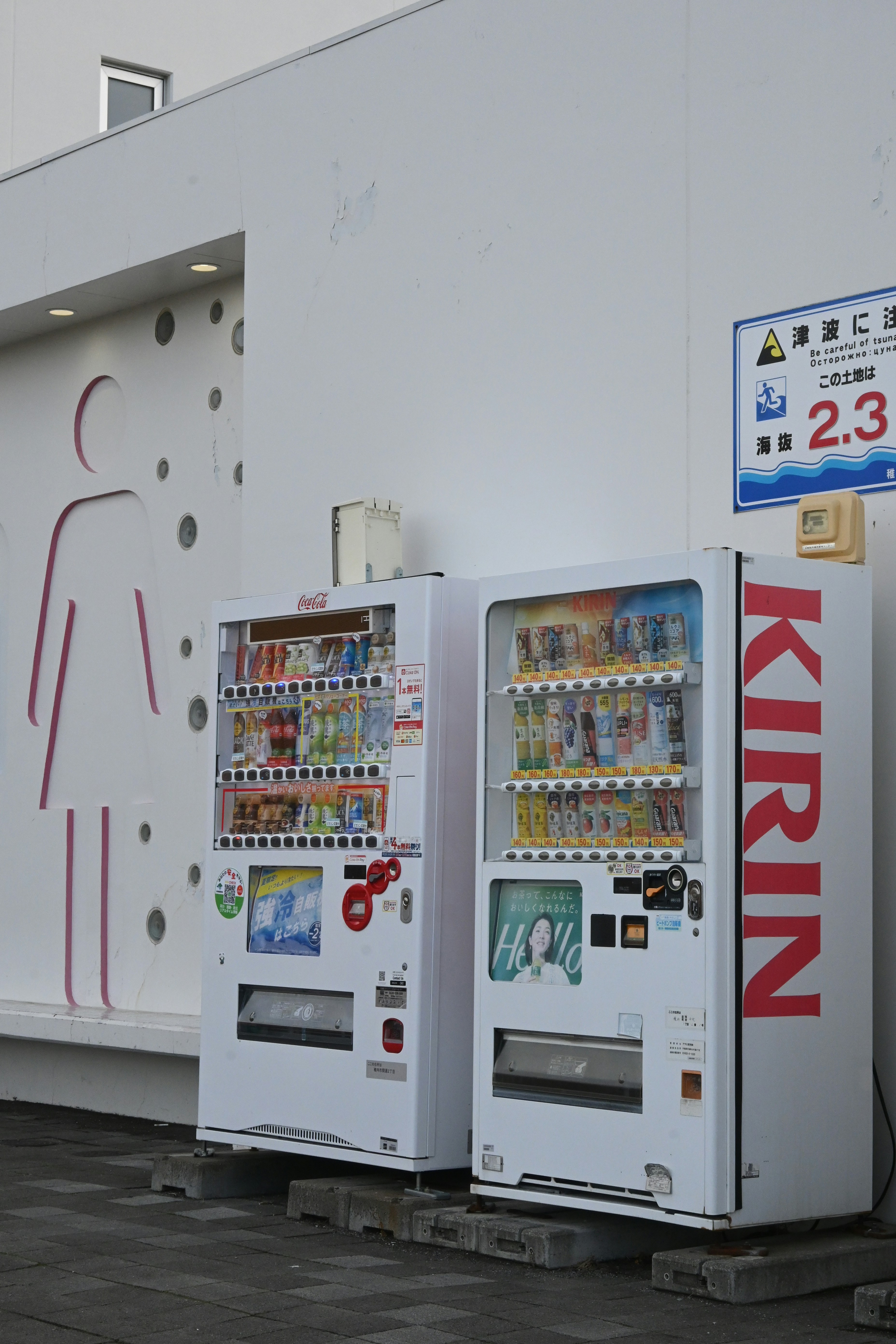 Two vending machines stand outside a building.