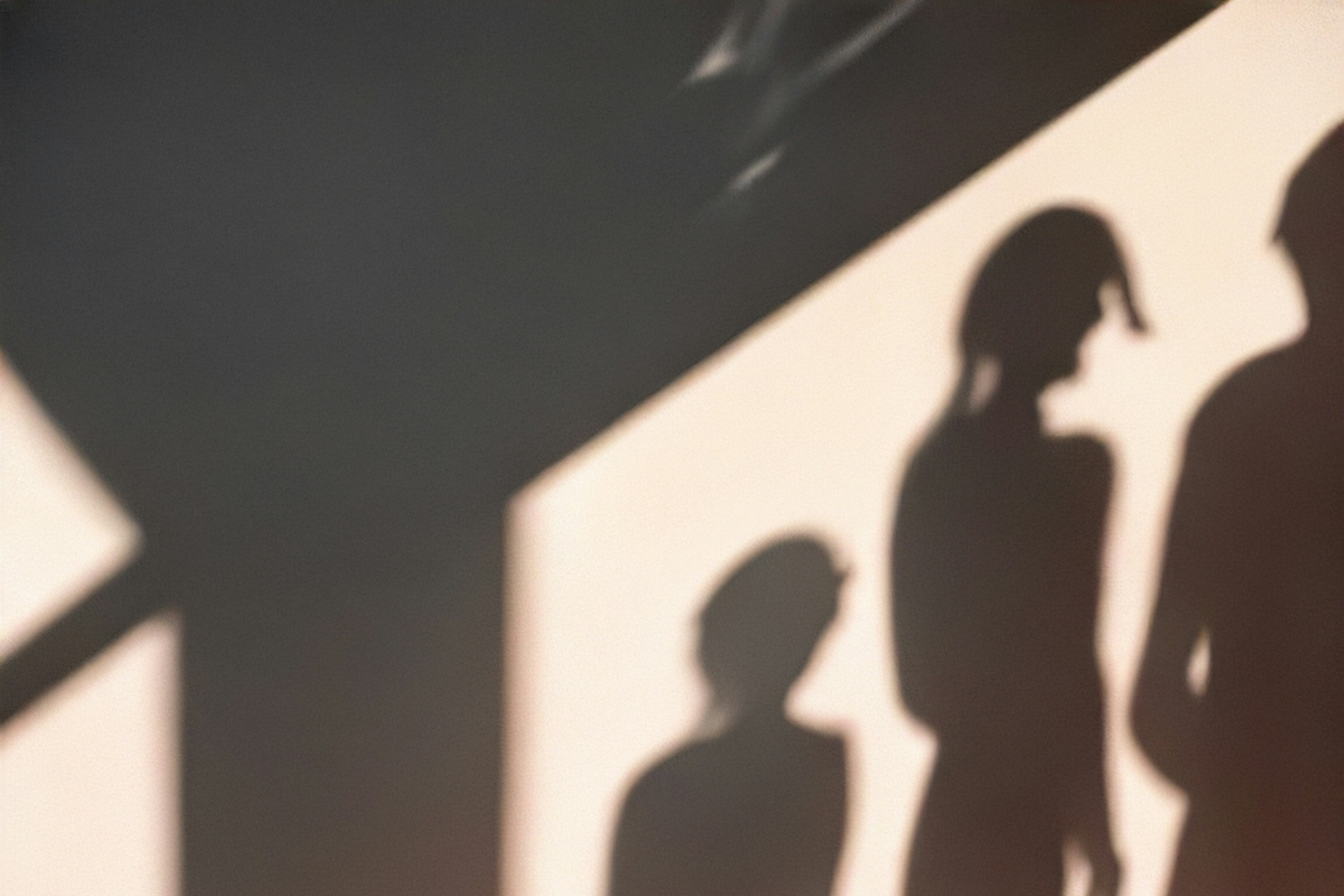 Shadows of three people on a wall.